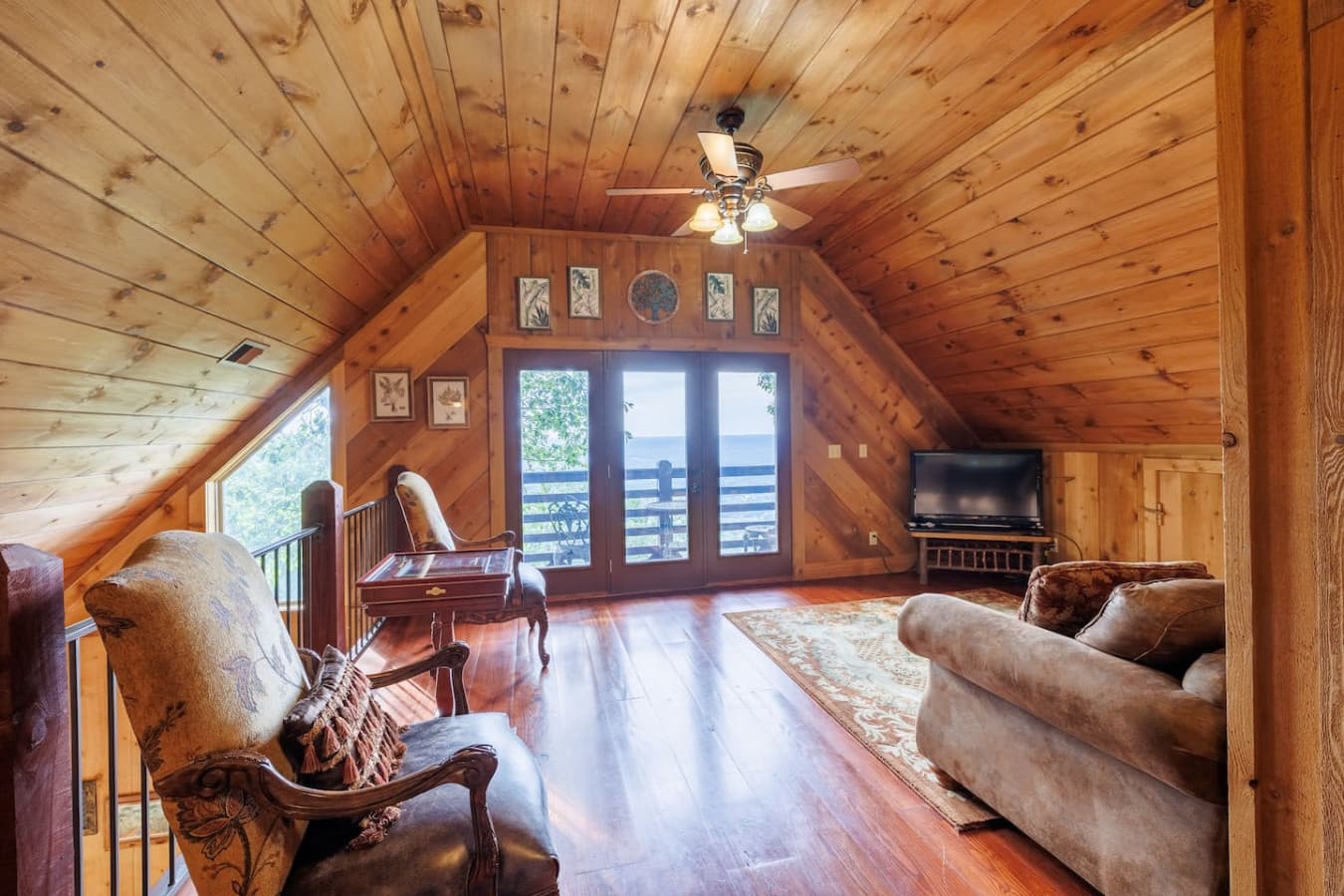 Upstairs seating area with views, balcony, and TV.