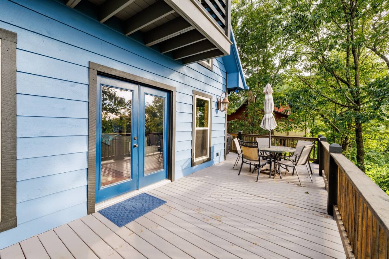 Back deck off of the living room with outdoor dining area and grill.