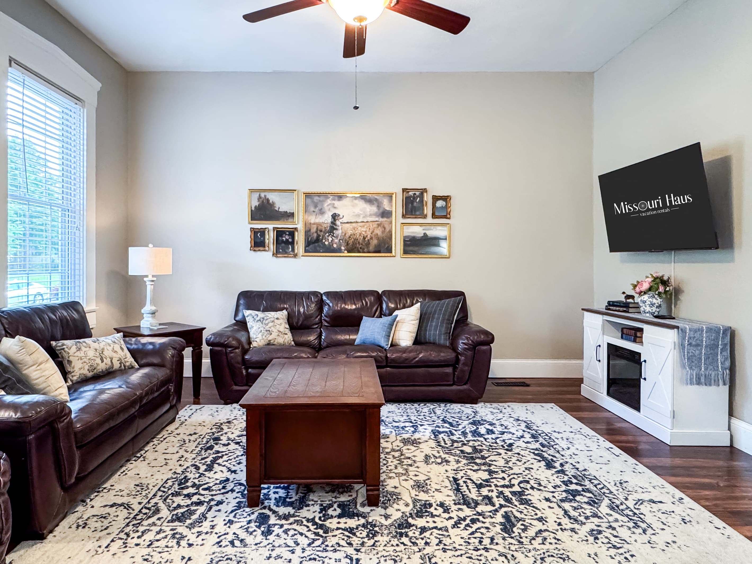 Warm and inviting Great Room with all the comforts of home - comfy leather couch, loveseat and recliner and Flat Screen Smart TV just off the kitchen for a perfect setup for families/groups to relax and reconnect at Aussie Cottage.