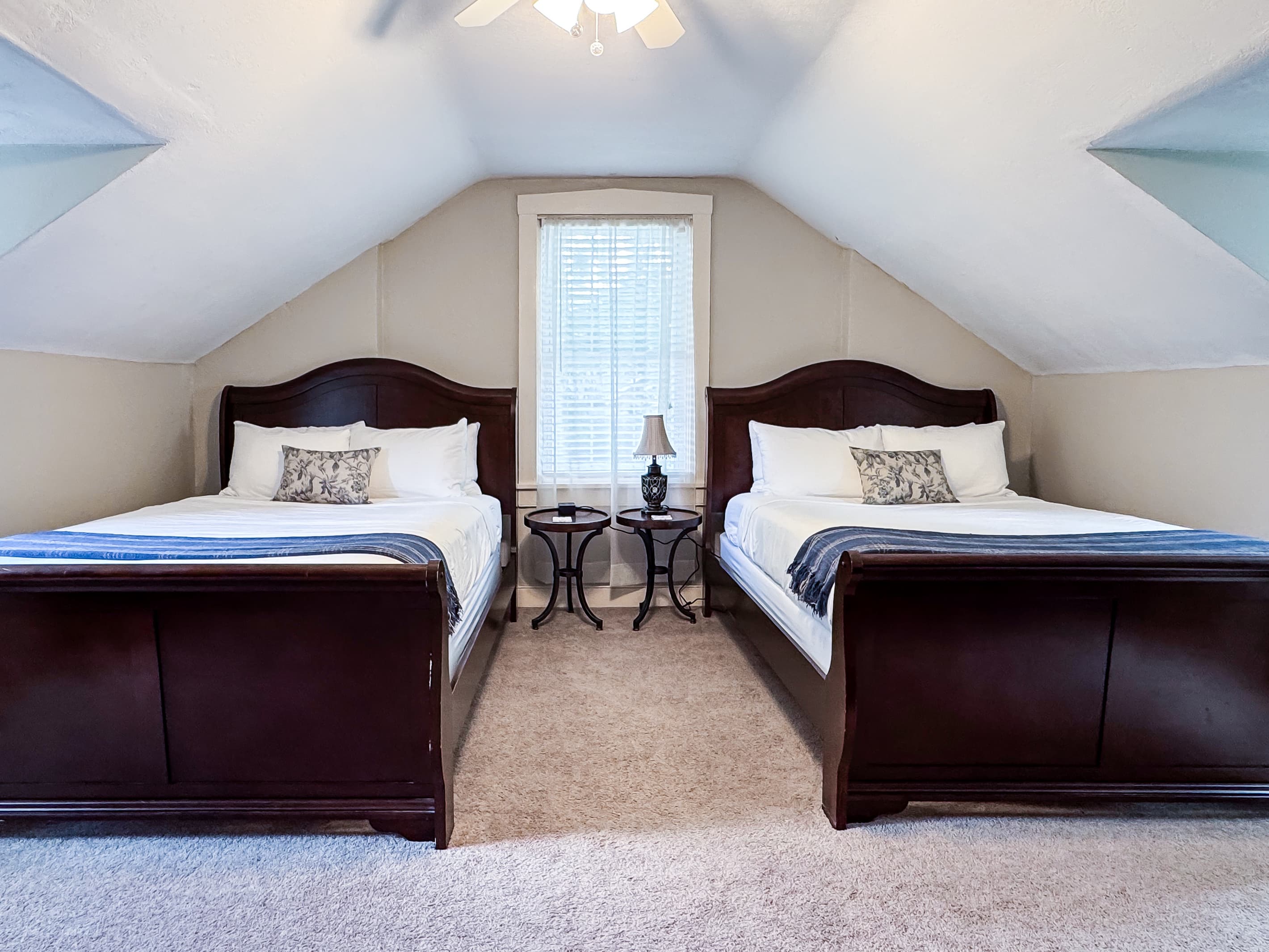 Upper level spacious bedroom with a two plush queen size beds with crisp white linens and second bathroom is on this level off the hall and has a step in shower at Aussie Cottage.