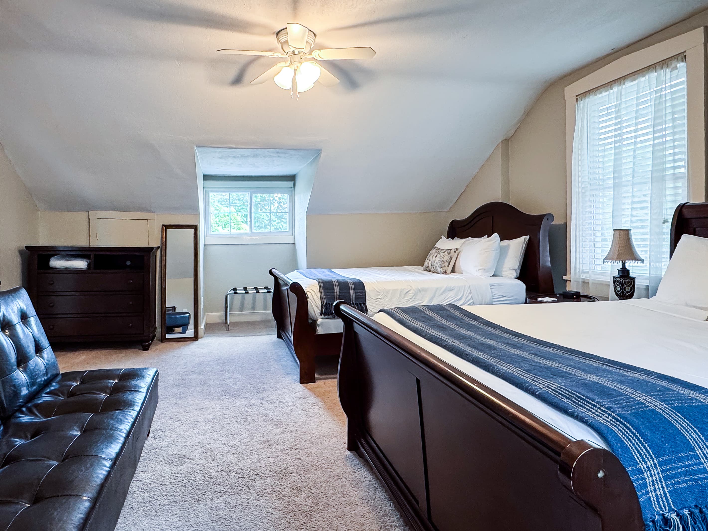 Upper level spacious bedroom with a two plush queen size beds with crisp white linens and second bathroom is on this level off the hall and has a step in shower at Aussie Cottage.