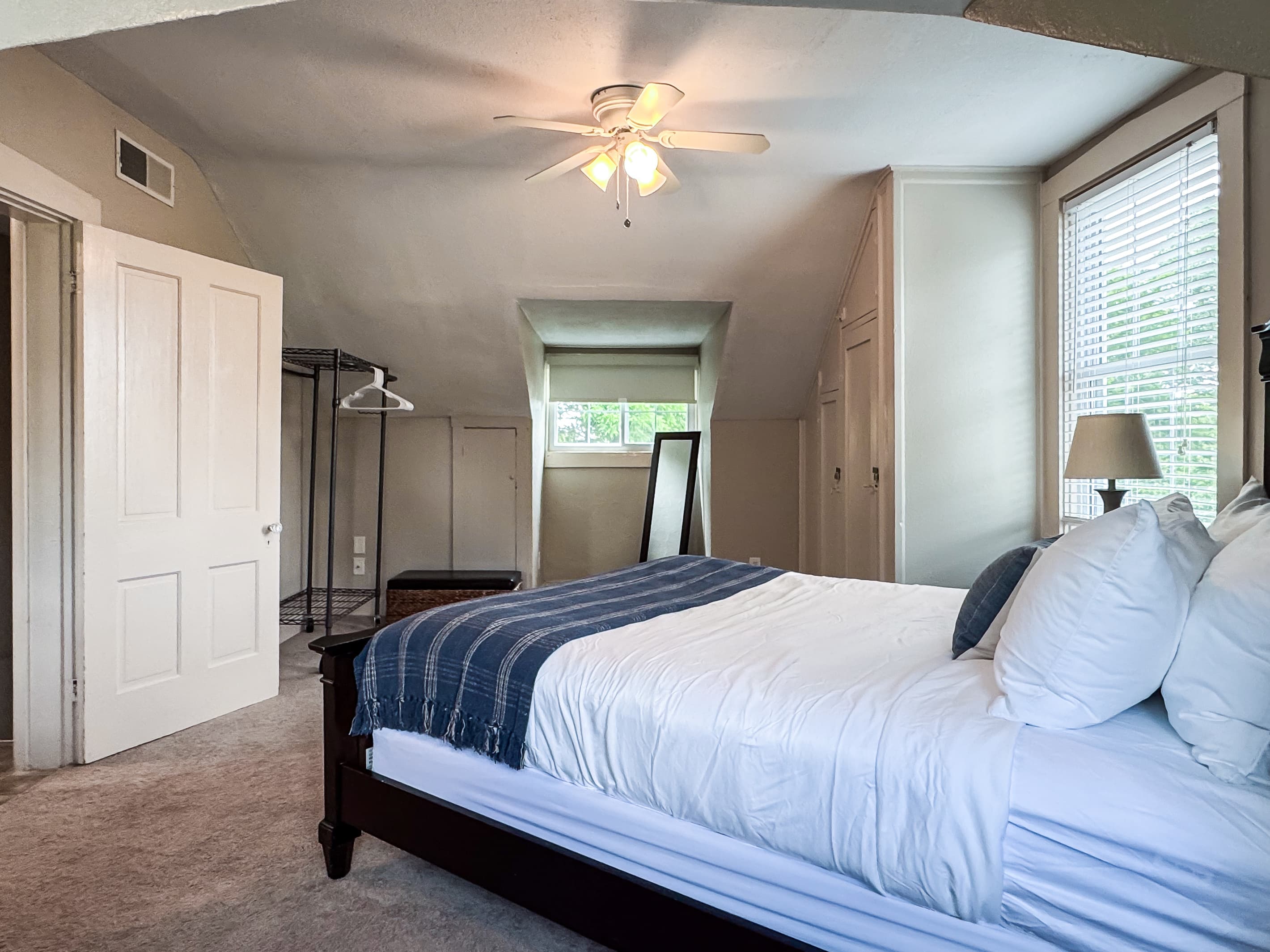 Upper level airy bedroom with a plush queen size bed with crisp white linens and second bathroom is on this level off the hall and has a step in shower at Aussie Cottage.