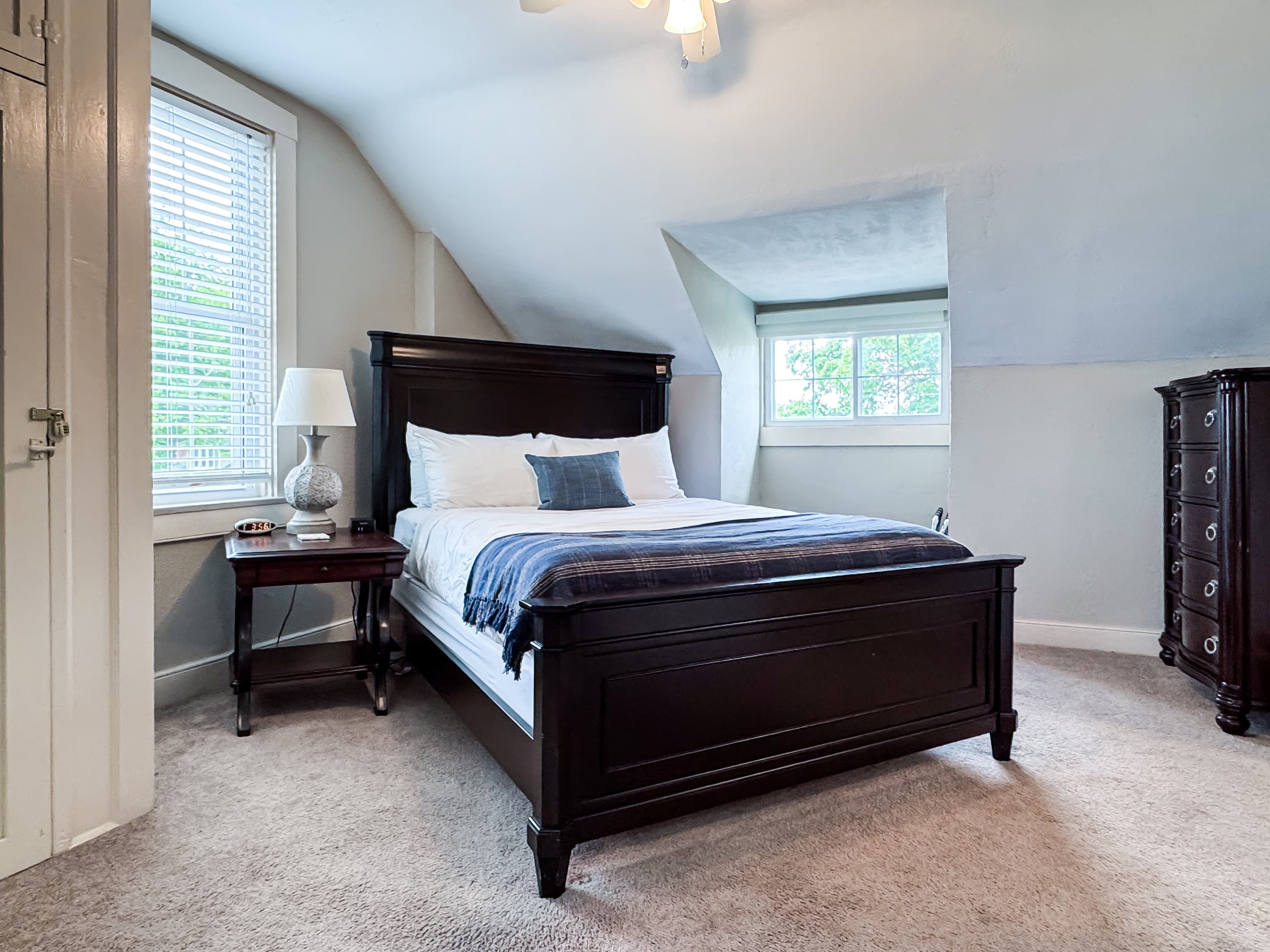 Upper level airy bedroom with a plush queen size bed with crisp white linens and second bathroom is on this level off the hall and has a step in shower at Aussie Cottage.