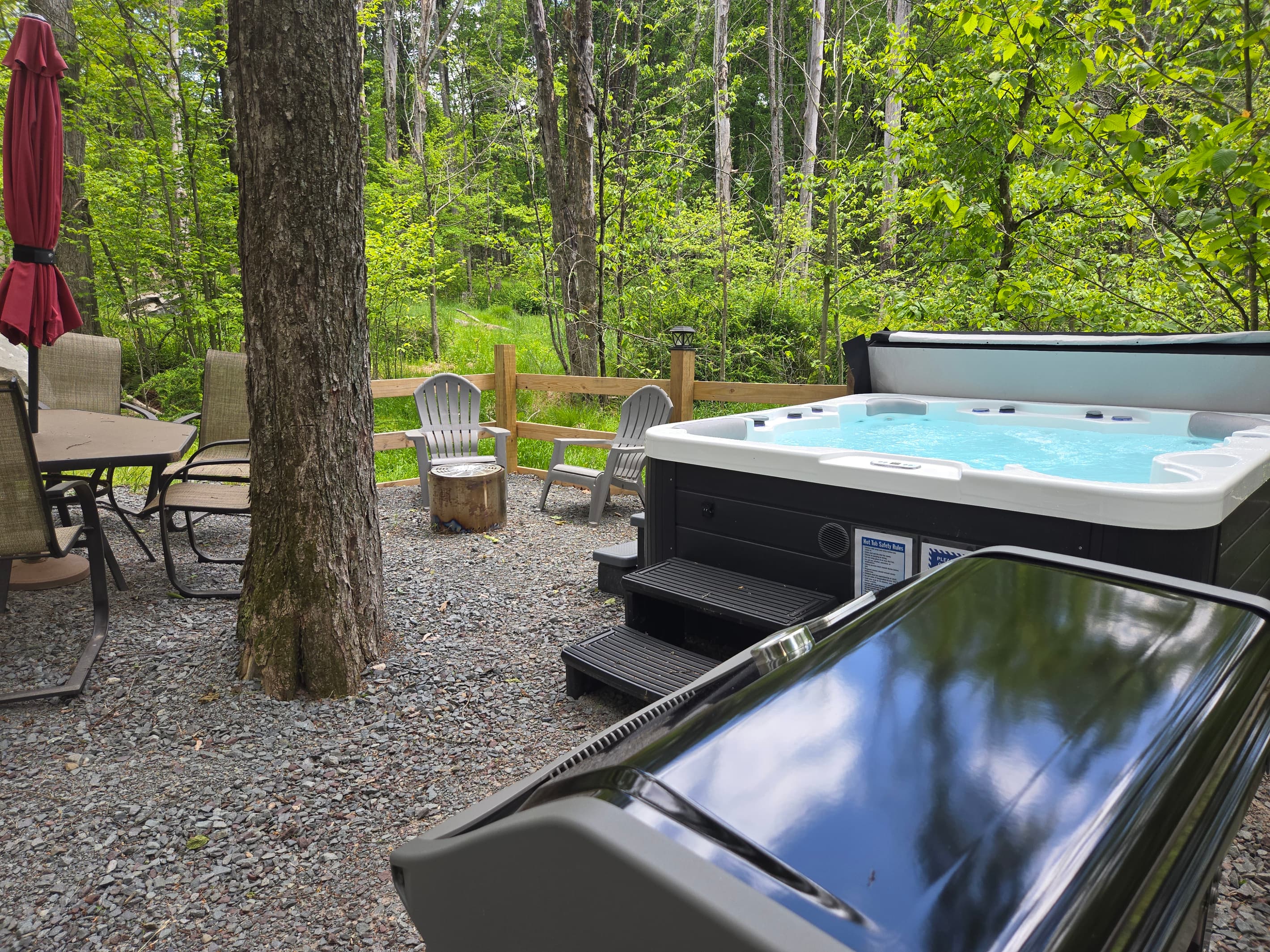 Backyard with hot tub, firepit, weber bbq grill, table with seating