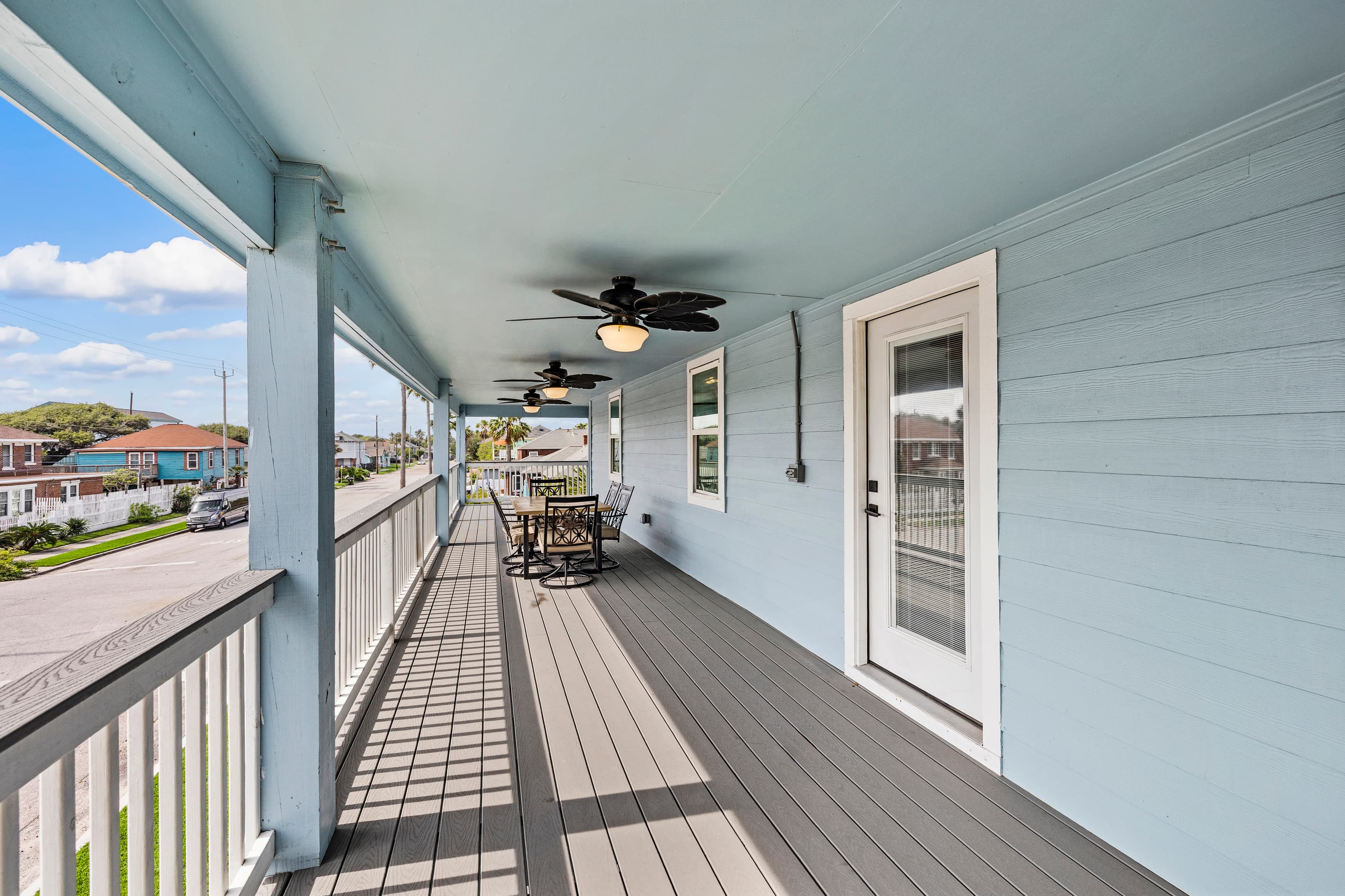 The private wraparound deck at The Lookout at R½ — ceiling fan overhead, seating at the far end, and Gulf breezes all day. Your outdoor living room above Galveston.