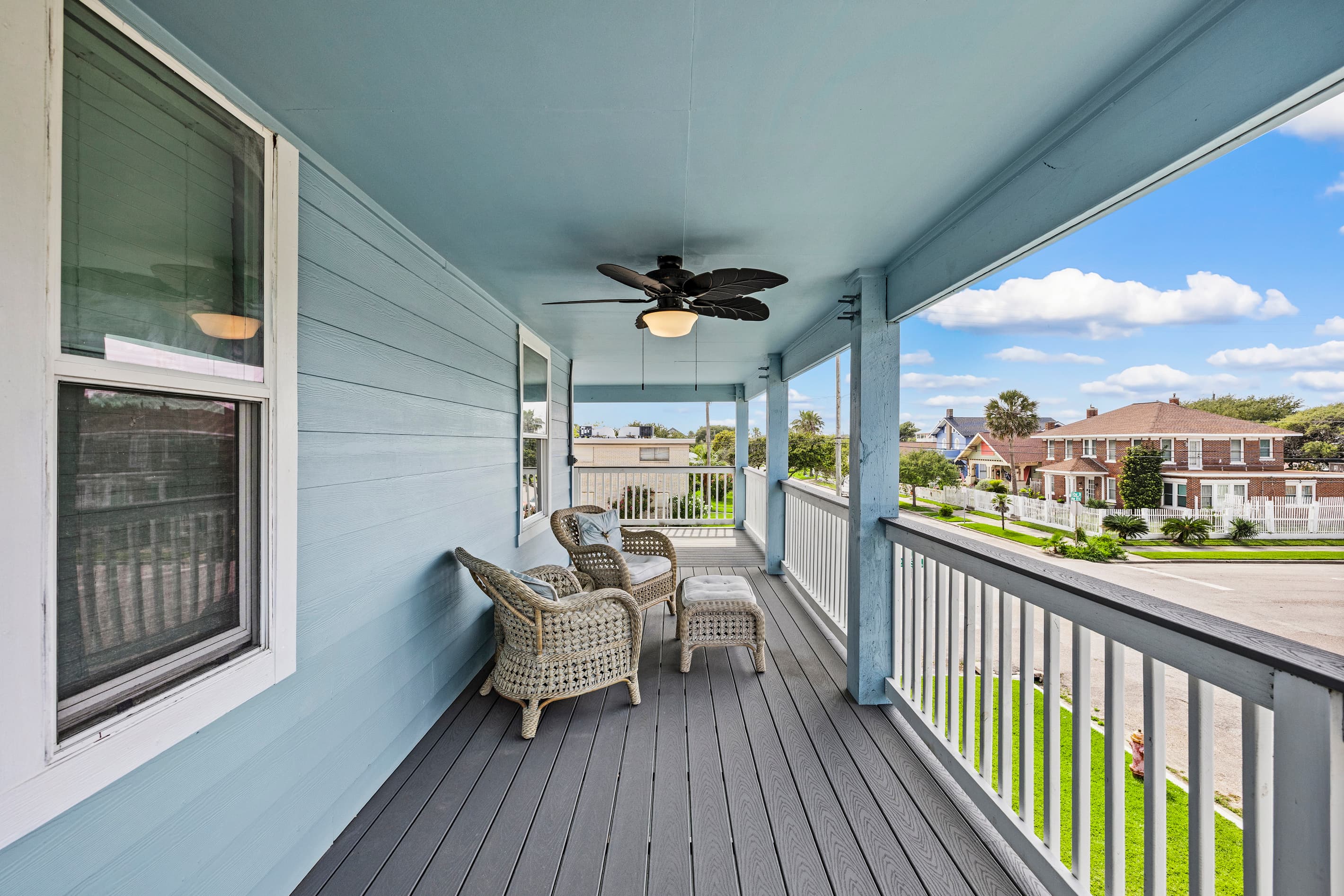 Morning coffee on the wraparound deck at The Lookout at R½ — wicker seating, Gulf breezes, and a front-row view over the Galveston Seawall neighborhood.