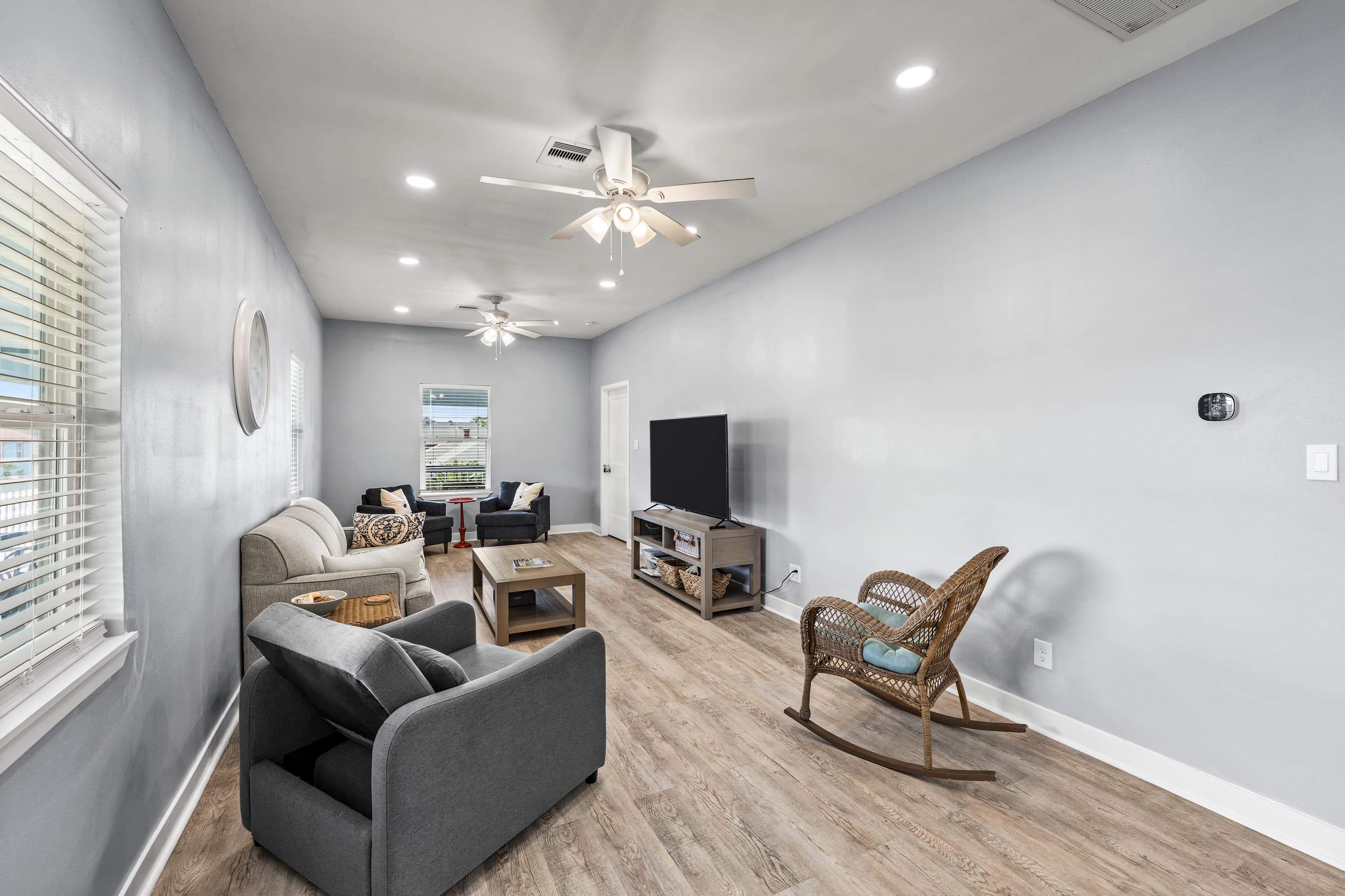 The living area at The Lookout at R½ — open plan with a plush sectional, smart TV, hardwood-style floors, and a ceiling fan. Comfortable space for the whole group.