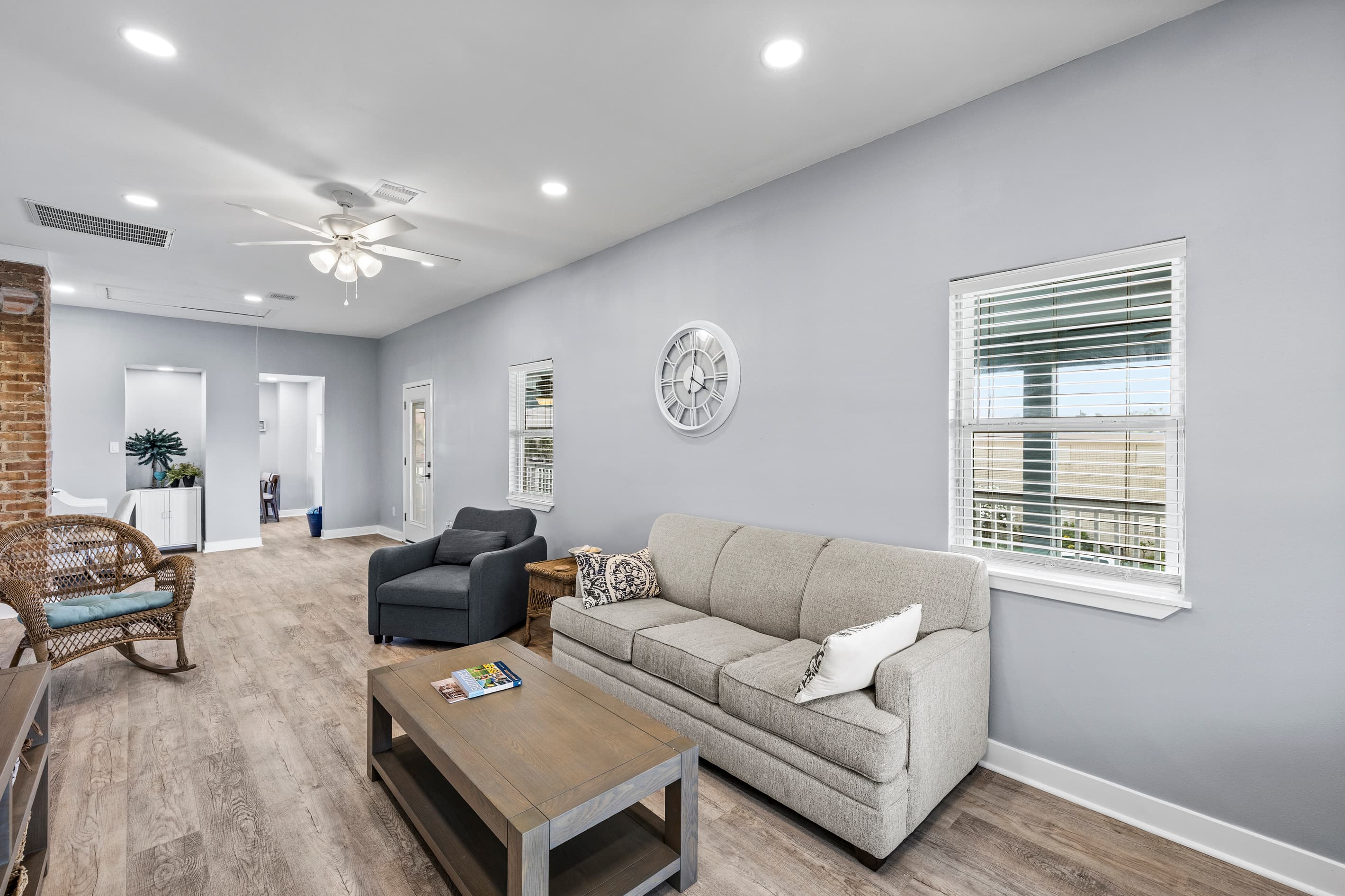 he living area at The Lookout at R½ features an exposed original brick accent — a nod to Galveston's historic character — with plush seating and hardwood-style floors throughout.