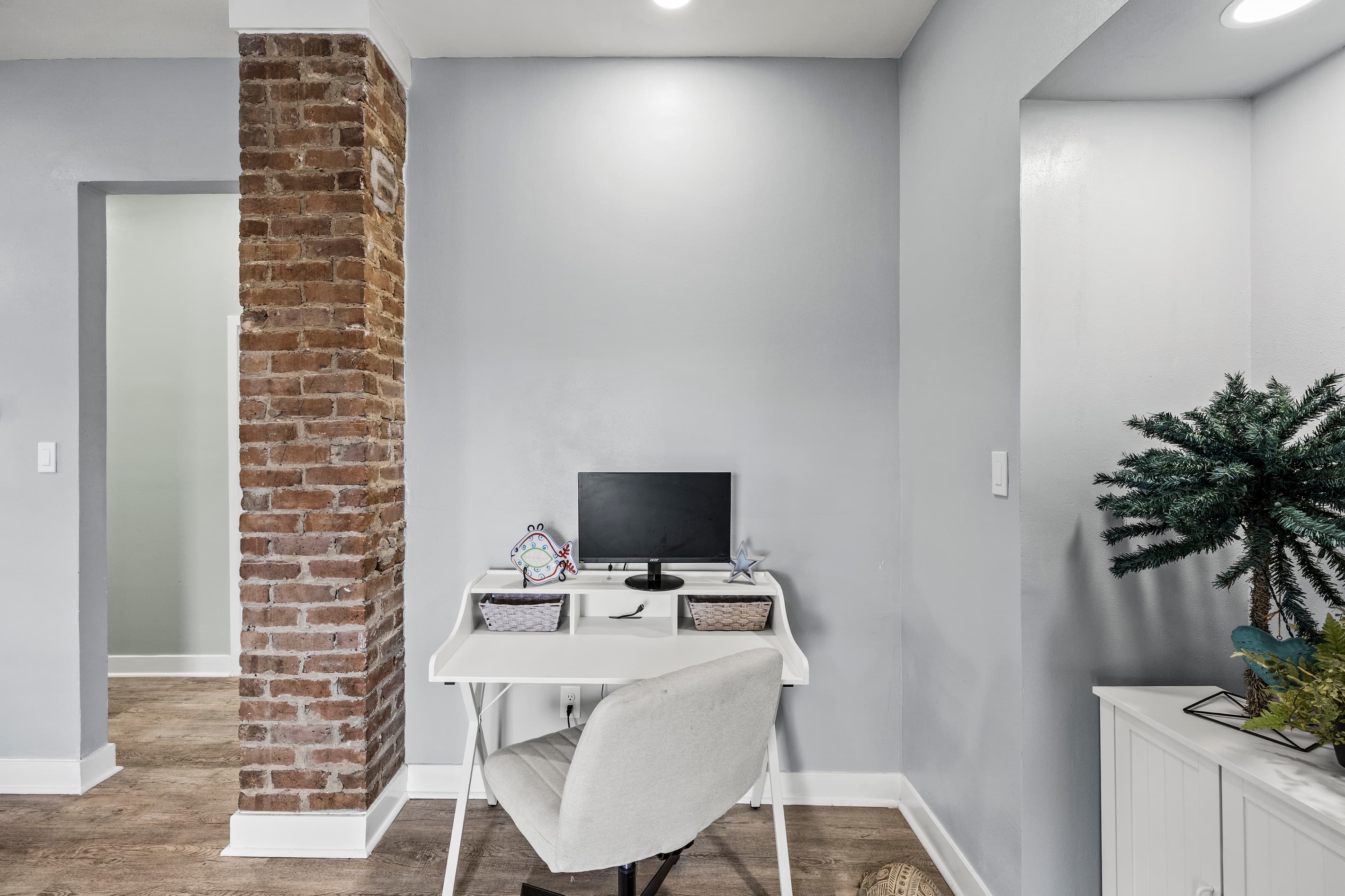 The dedicated workspace at The Lookout at R½ — original exposed brick, full desk setup, and a private glass entry. Vacation longer without going offline.