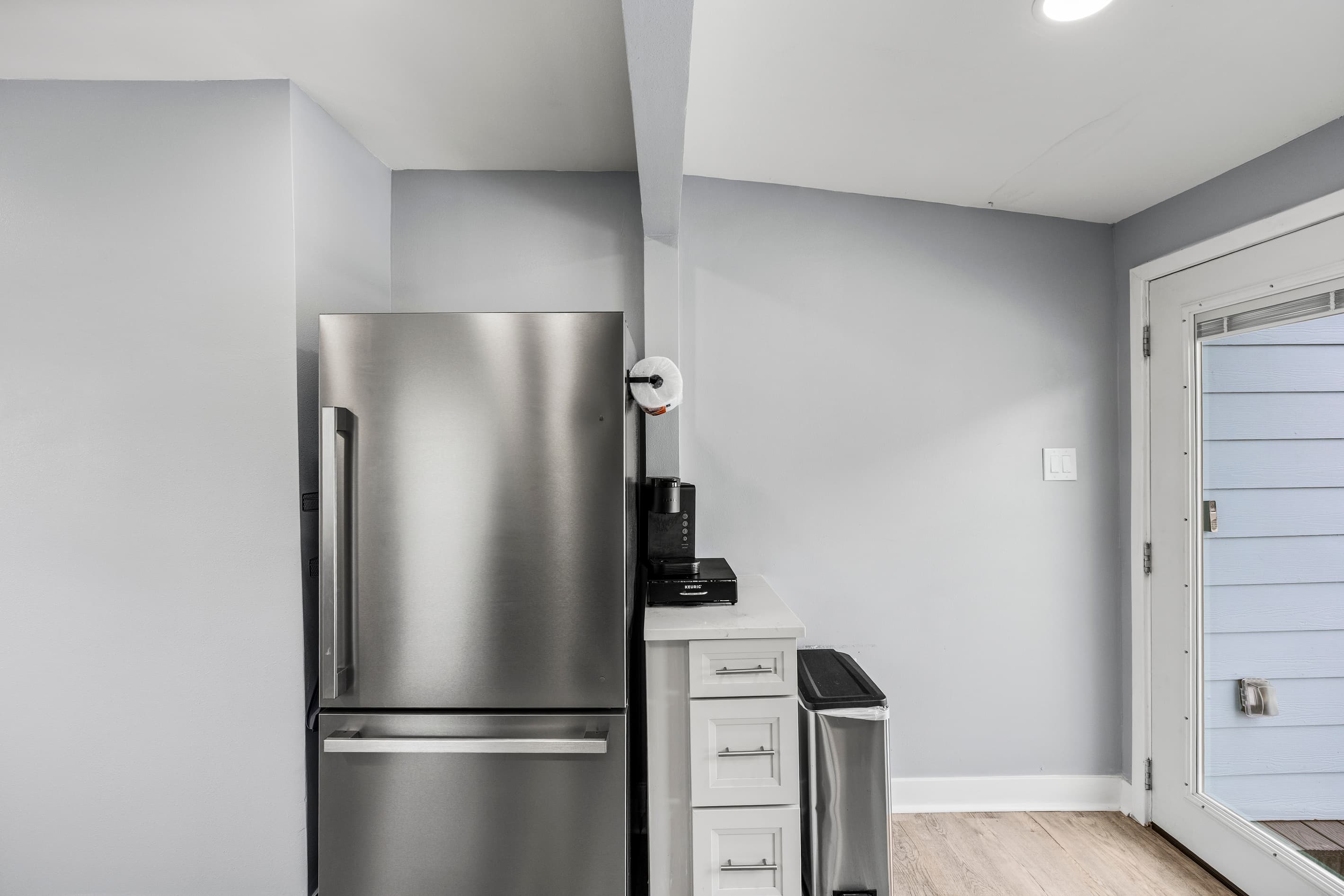 Full-size stainless fridge and coffee station at The Lookout at R½ — fully stocked for your stay, with a French door opening directly to the wraparound deck.