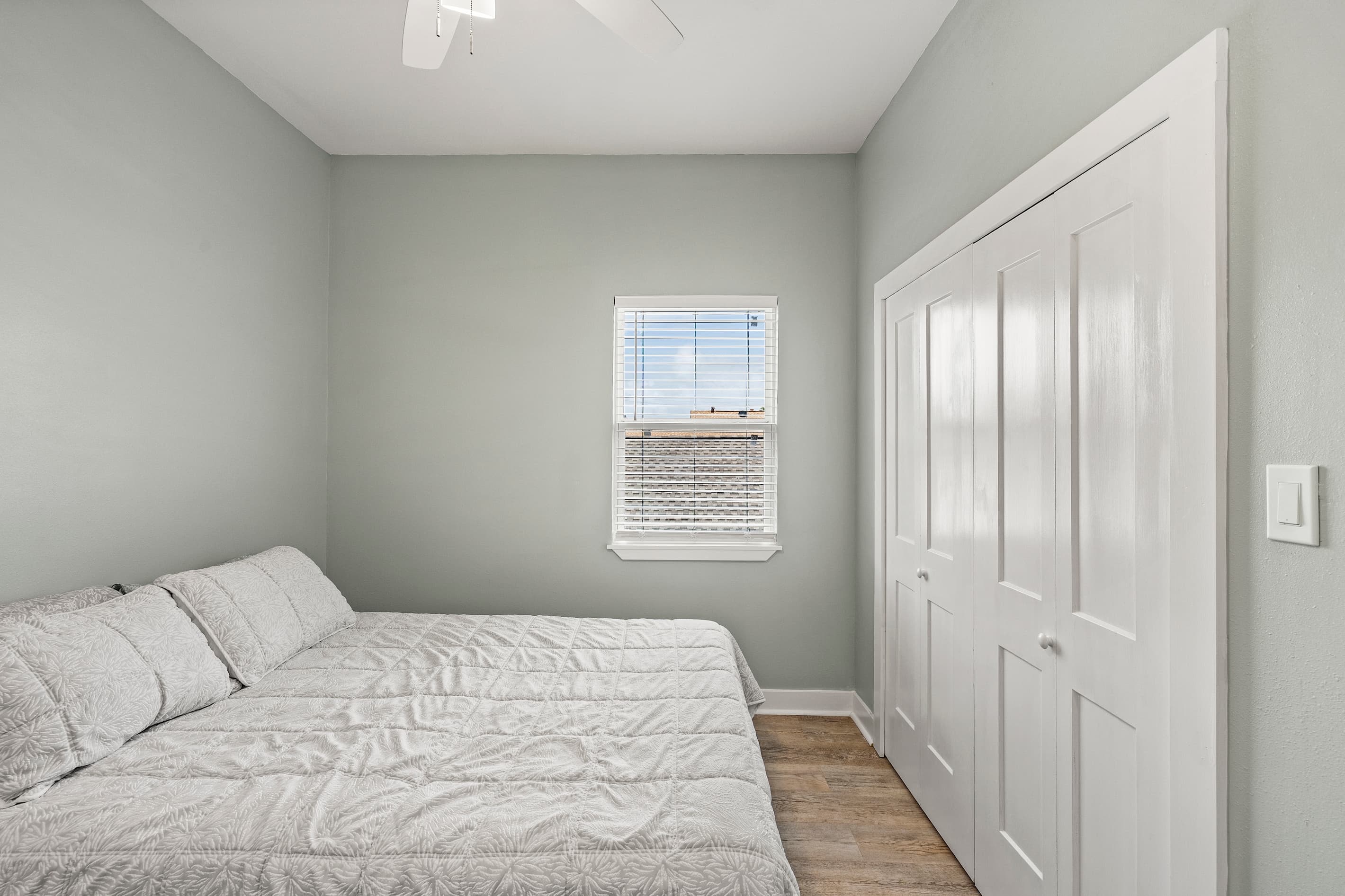 Bedroom 1 at The Lookout at R½ — a queen bed, generous closet storage, and natural light. A calm, comfortable retreat after a day on the Galveston Seawall.