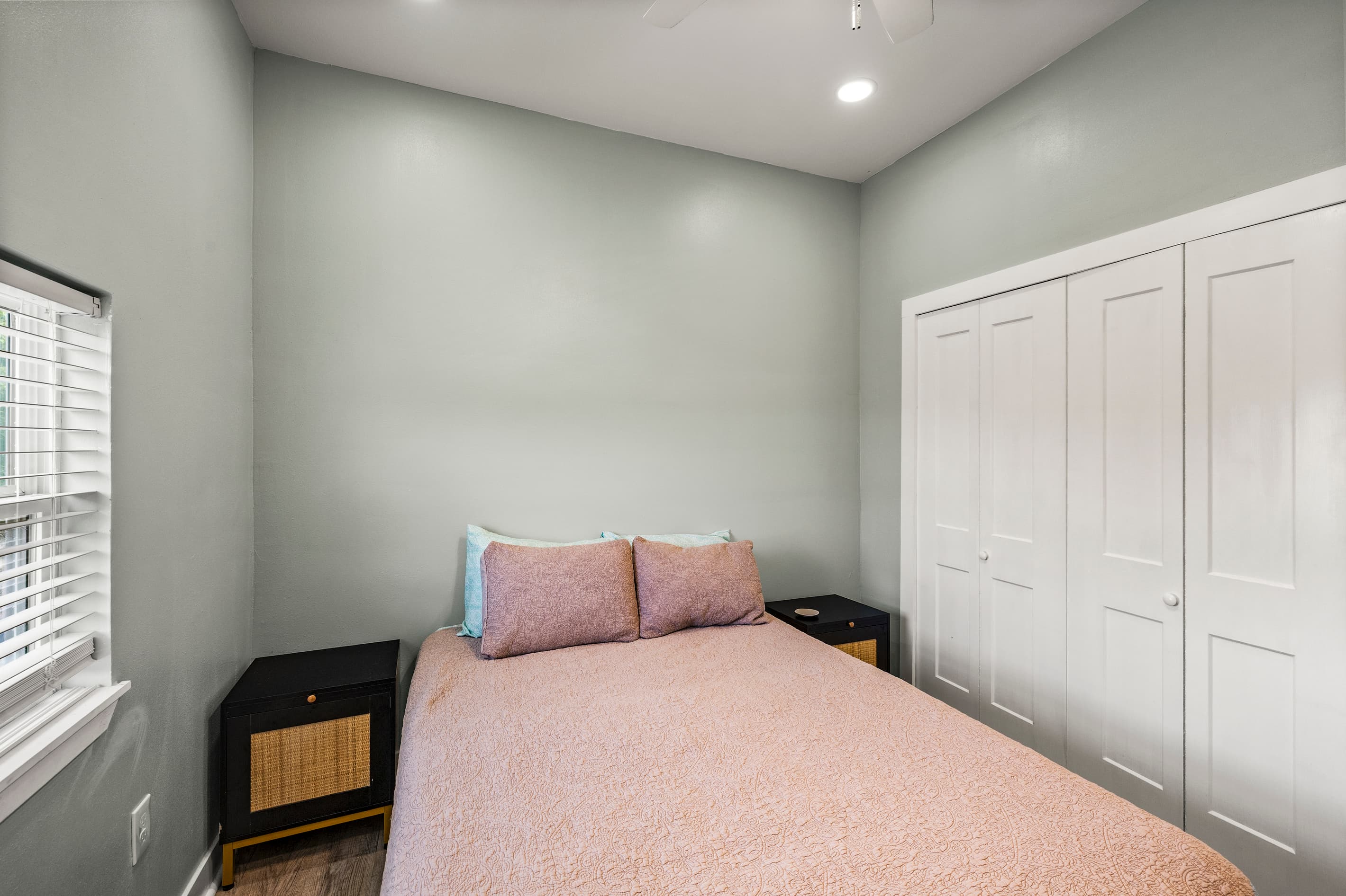Bedroom 2 at The Lookout at R½ — full closet storage, dark wood nightstands, and a quiet window with natural light. Comfortable and restful for a longer stay.