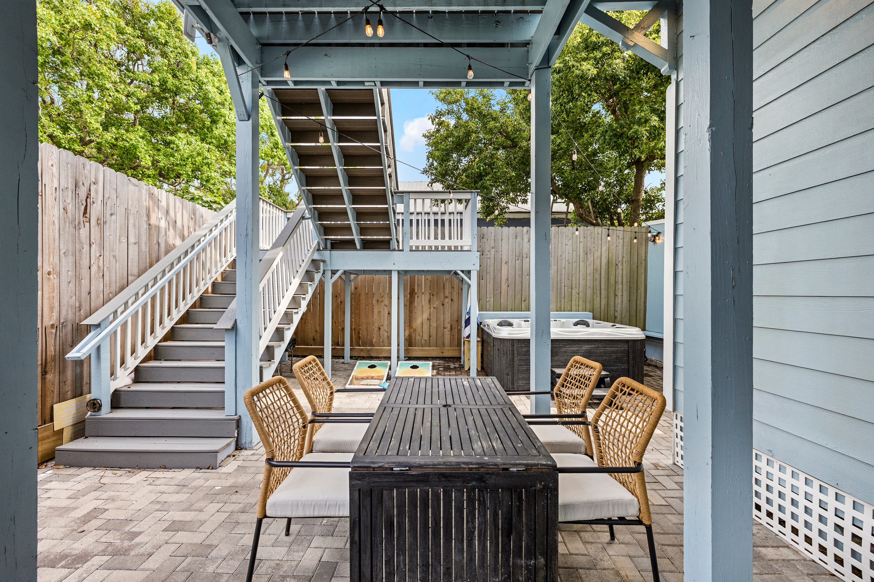Dine, and gather in the private fenced courtyard at The Lookout at R½ — pergola seating, and the wraparound deck staircase just steps away.