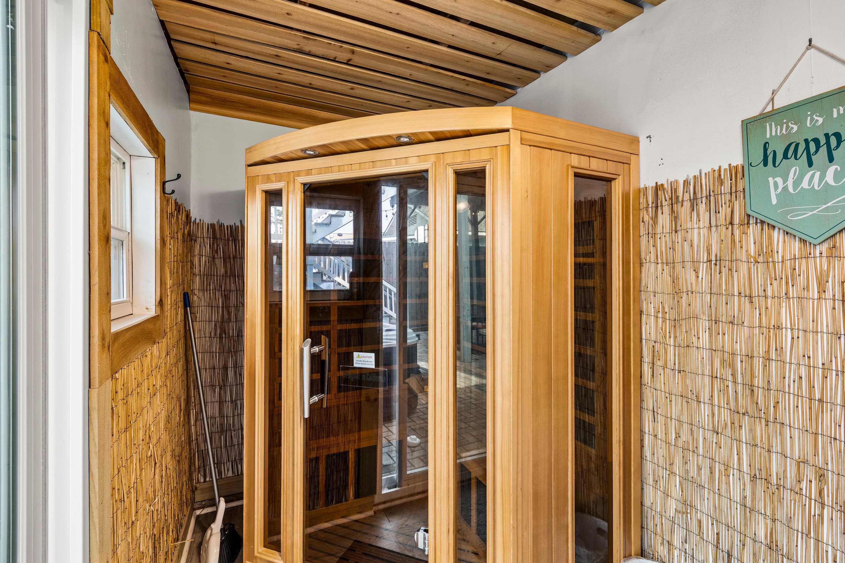 The private outdoor sauna at The Lookout at R½ — beautiful cedar construction with glass door, tucked into a bamboo-walled spa area. Hot tub AND sauna: the ultimate recovery combo.