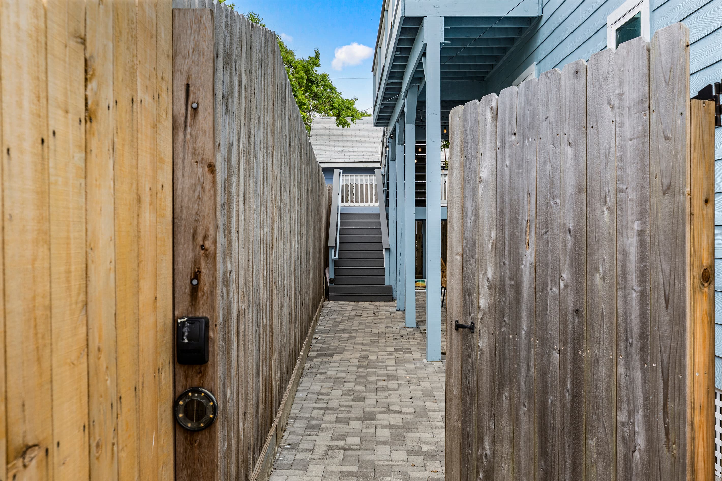 The private gated entrance to the outdoor spa at The Lookout at R½ — a fenced passage leading to the sauna, outdoor restroom, and hot tub courtyard. Completely secluded.