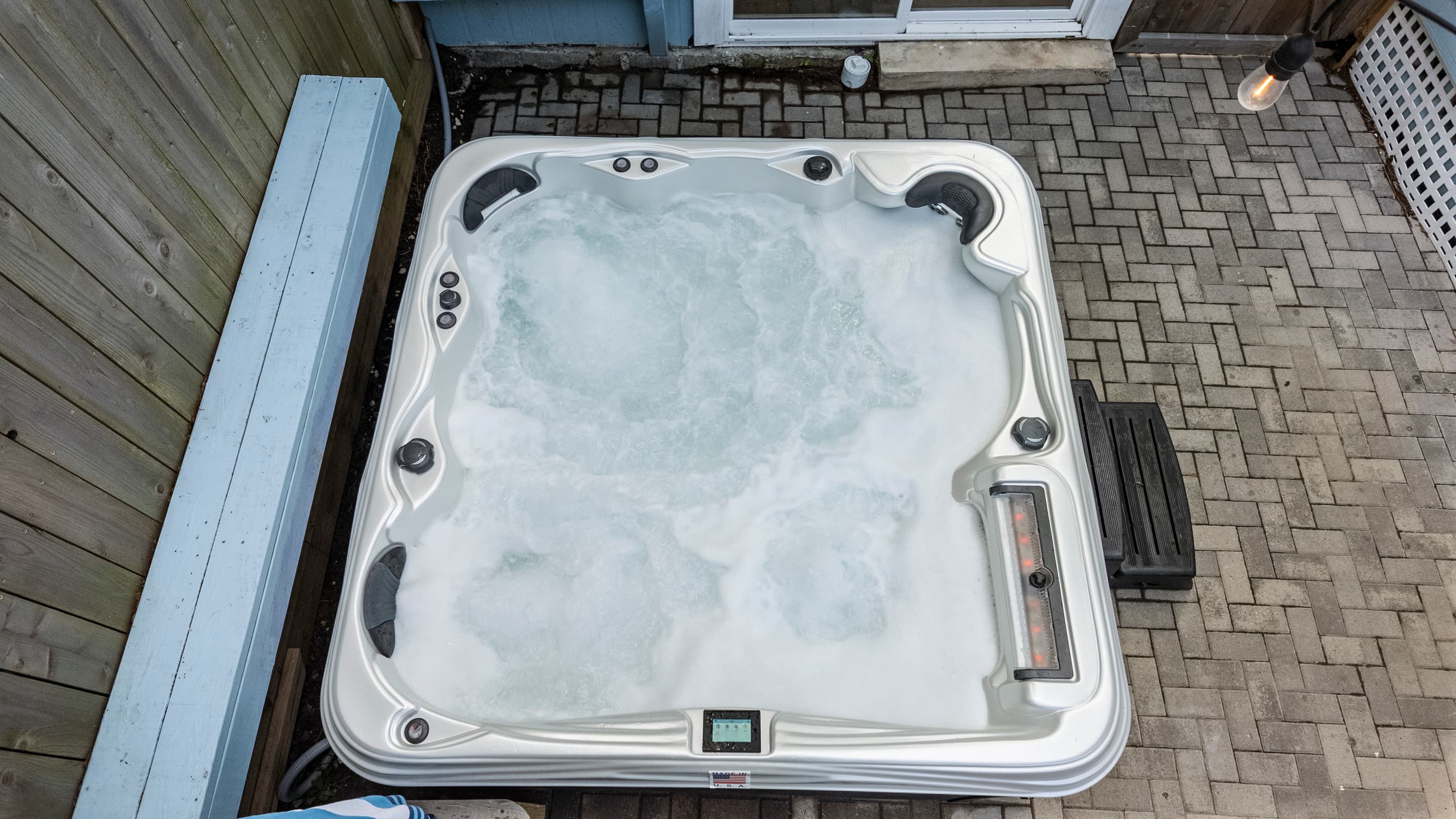 The private hot tub at The Lookout at R½ — jets bubbling, seating for the whole group, and a paver courtyard surrounding it. Step in any time of day or night.