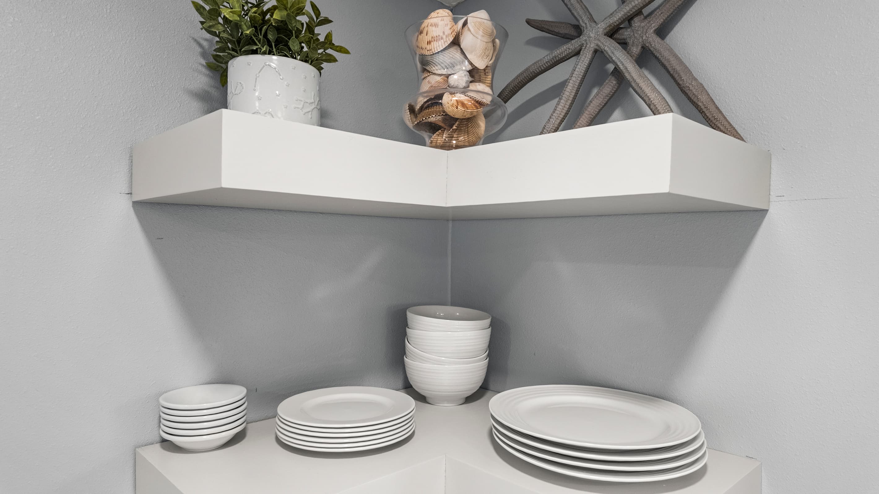 The kitchen at The Lookout at R½ comes fully stocked — plates, bowls, and coastal décor on open shelving. Real meals, no paper plates required.