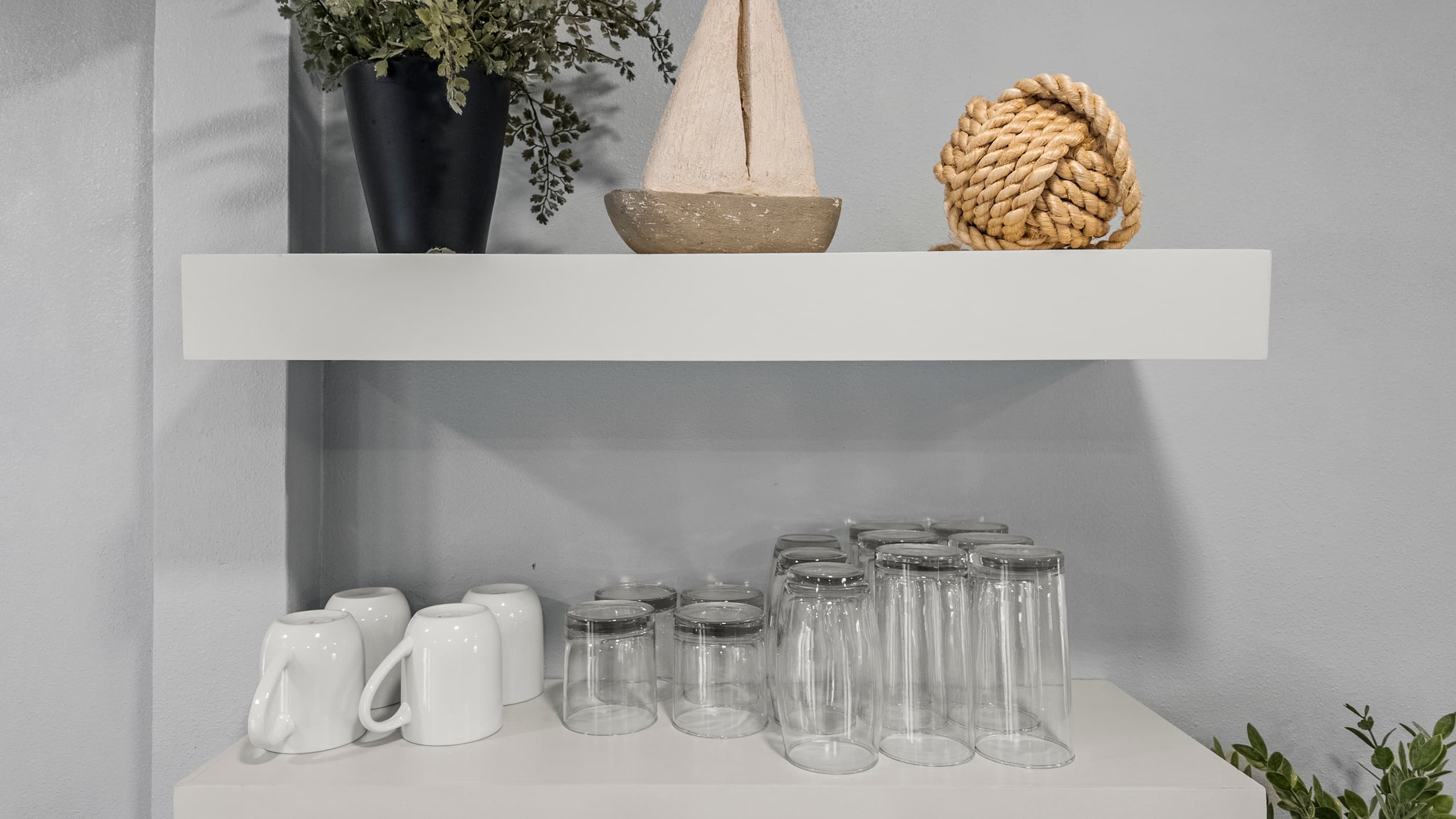 Mugs, mason jar glasses, and coastal details at The Lookout at R½ — open shelving stocked for every occasion, from morning coffee to evening drinks on the deck.