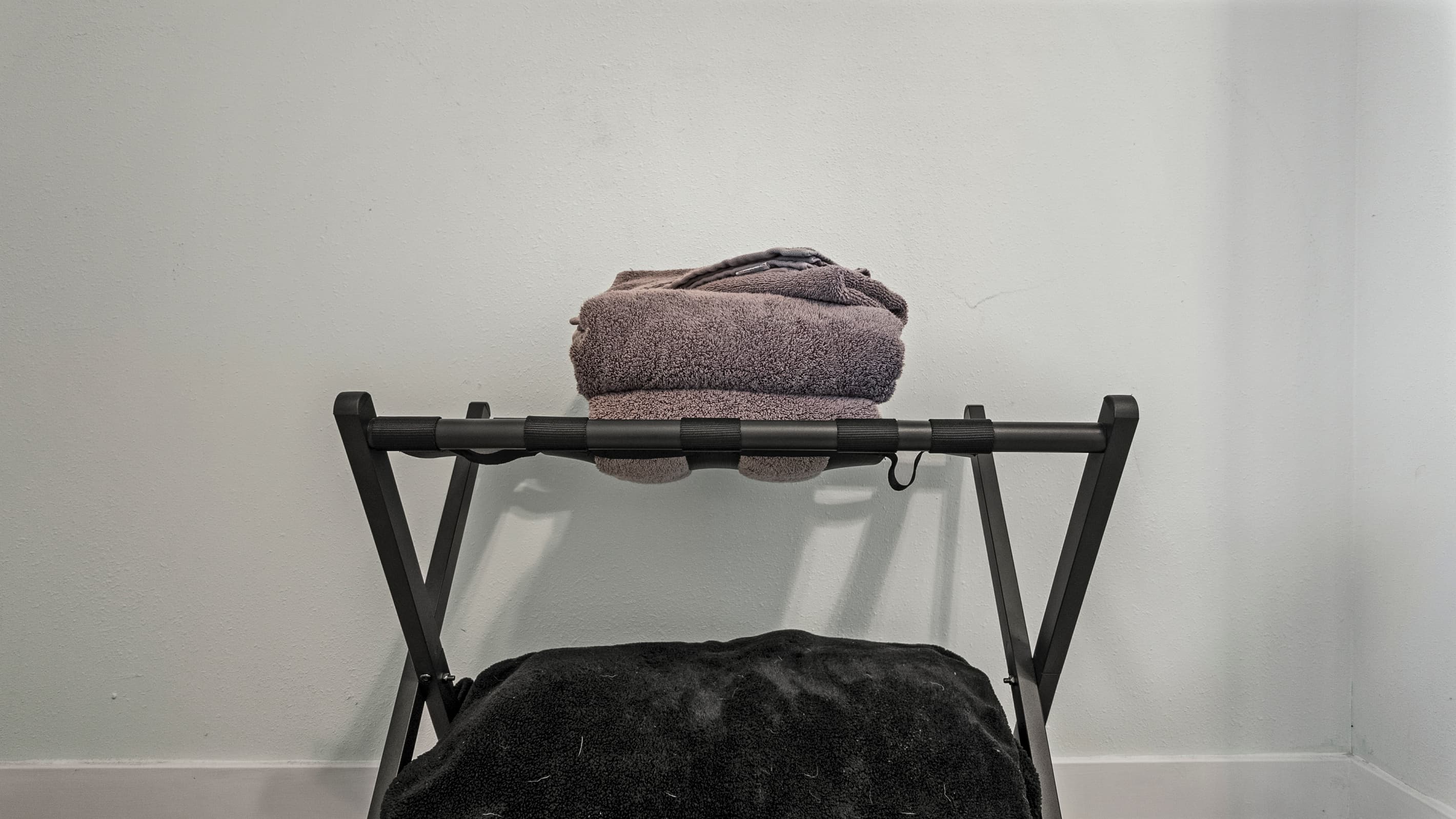 Luggage rack and fresh towels ready in Bedroom 2 at The Lookout at R½ — the small details that make the difference between a house and a proper vacation rental.