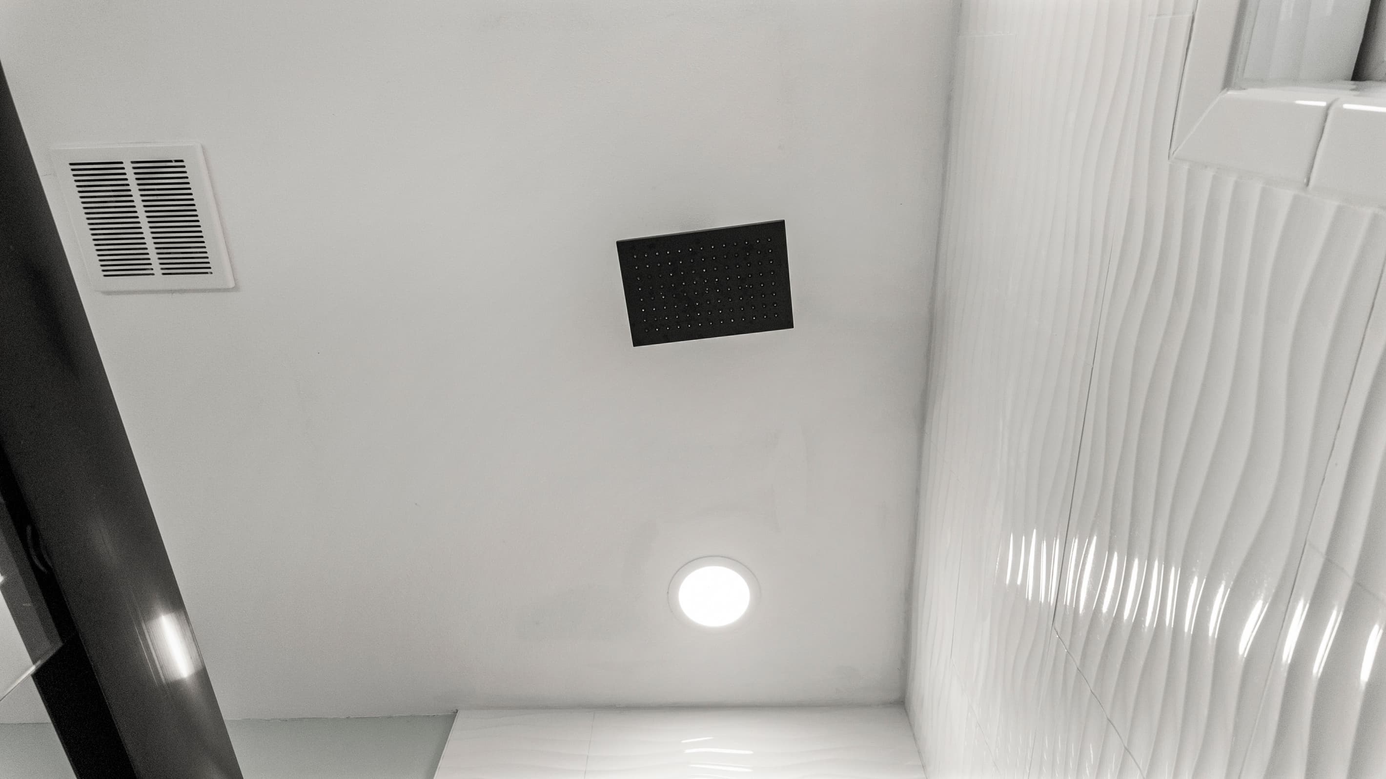 Rain shower head at The Lookout at R½ — a full rainfall experience in the glass-enclosed walk-in shower. The best way to start every morning on the Galveston Seawall.