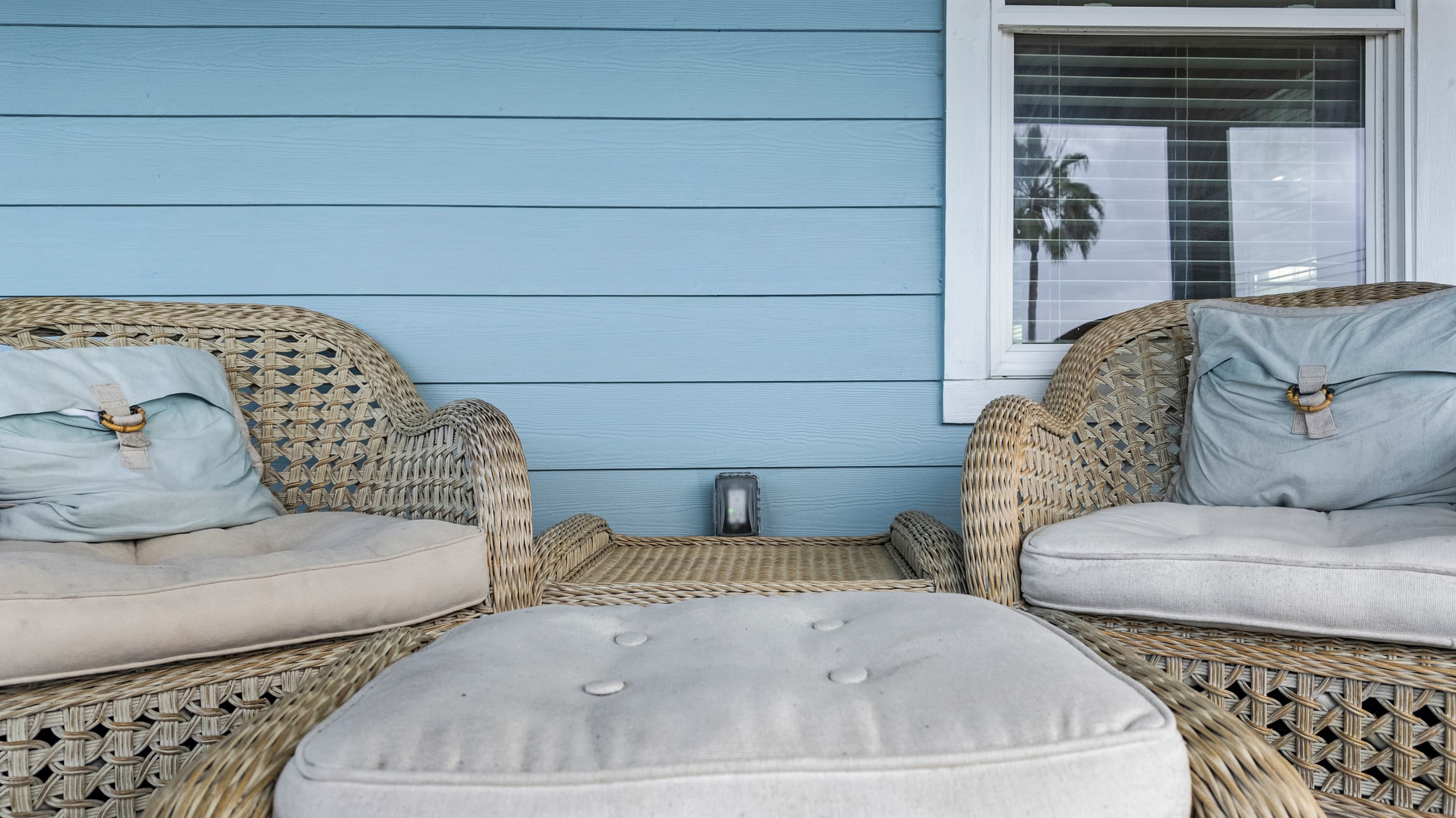 Wicker lounge seating on the wraparound deck at The Lookout at R½ — cushioned chairs, a plush ottoman, and Gulf breezes all afternoon. Pull up a seat and stay a while.
