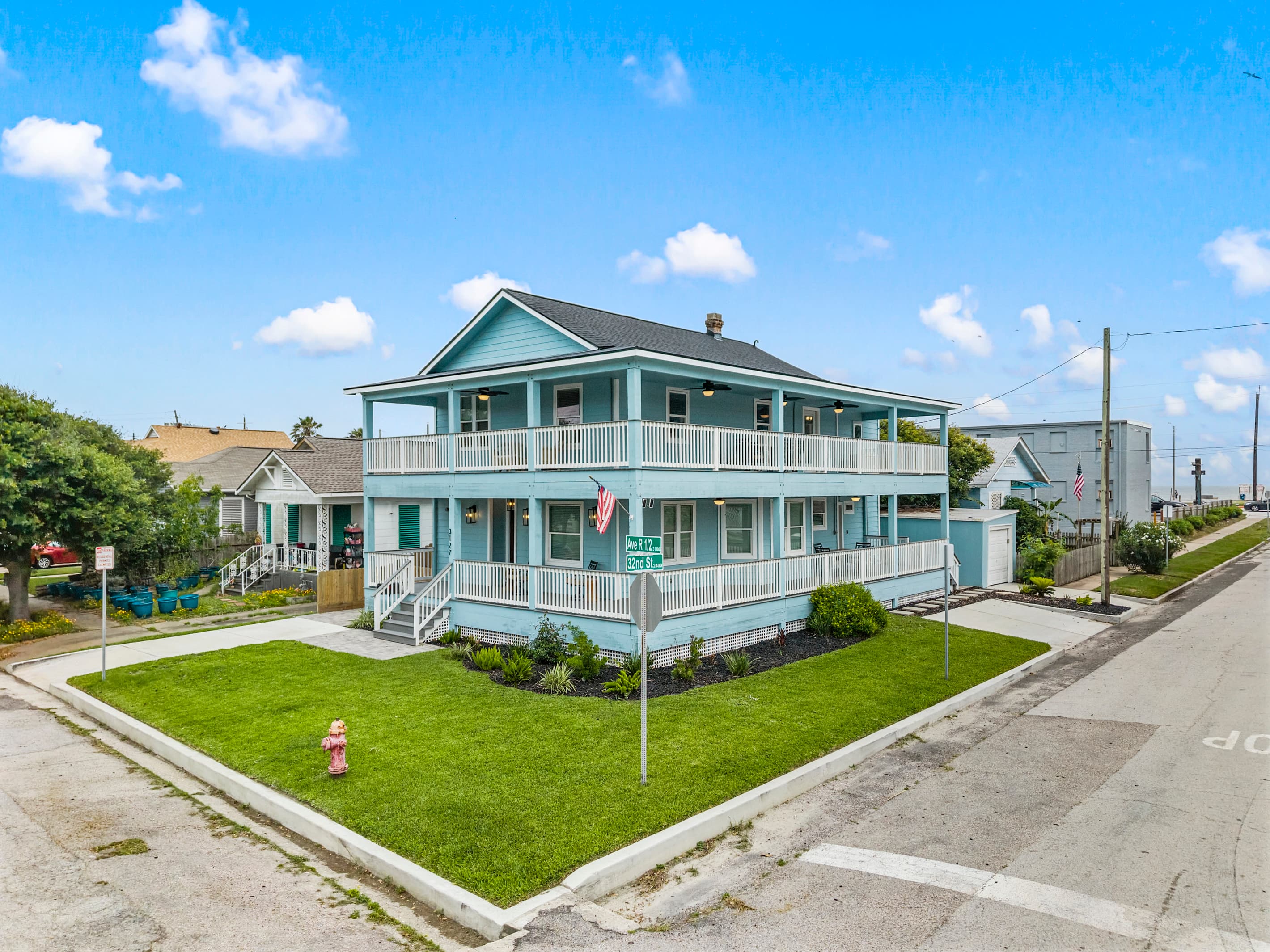 The corner lot at The Lookout at R½ — open views in every direction, wraparound decks on both levels, and well-kept lawn right on the Galveston Seawall.