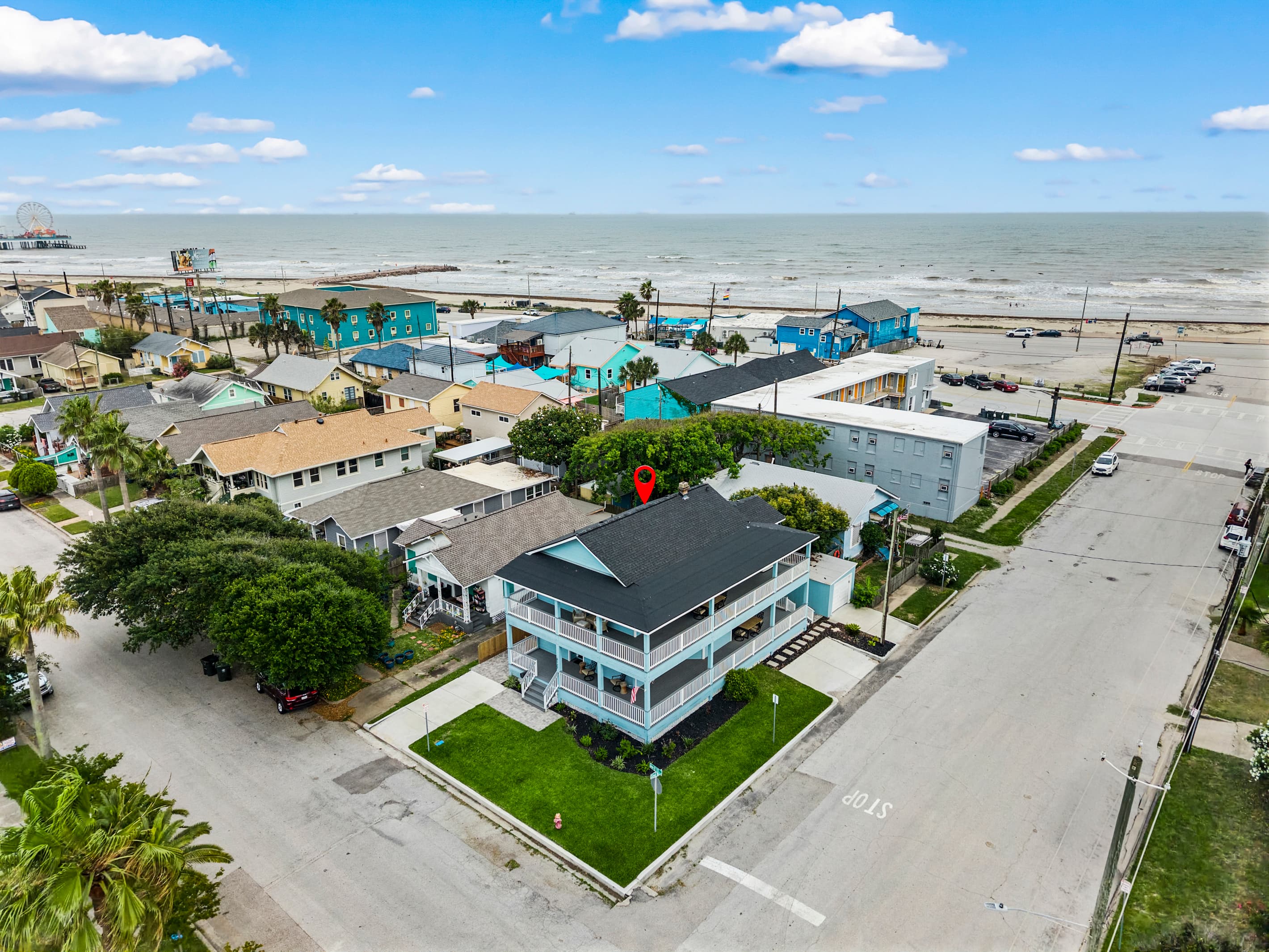 Aerial view of The Lookout at R½ on the Galveston Seawall — the beach and Gulf of Mexico are steps from the front door. No car required for a full beach day.