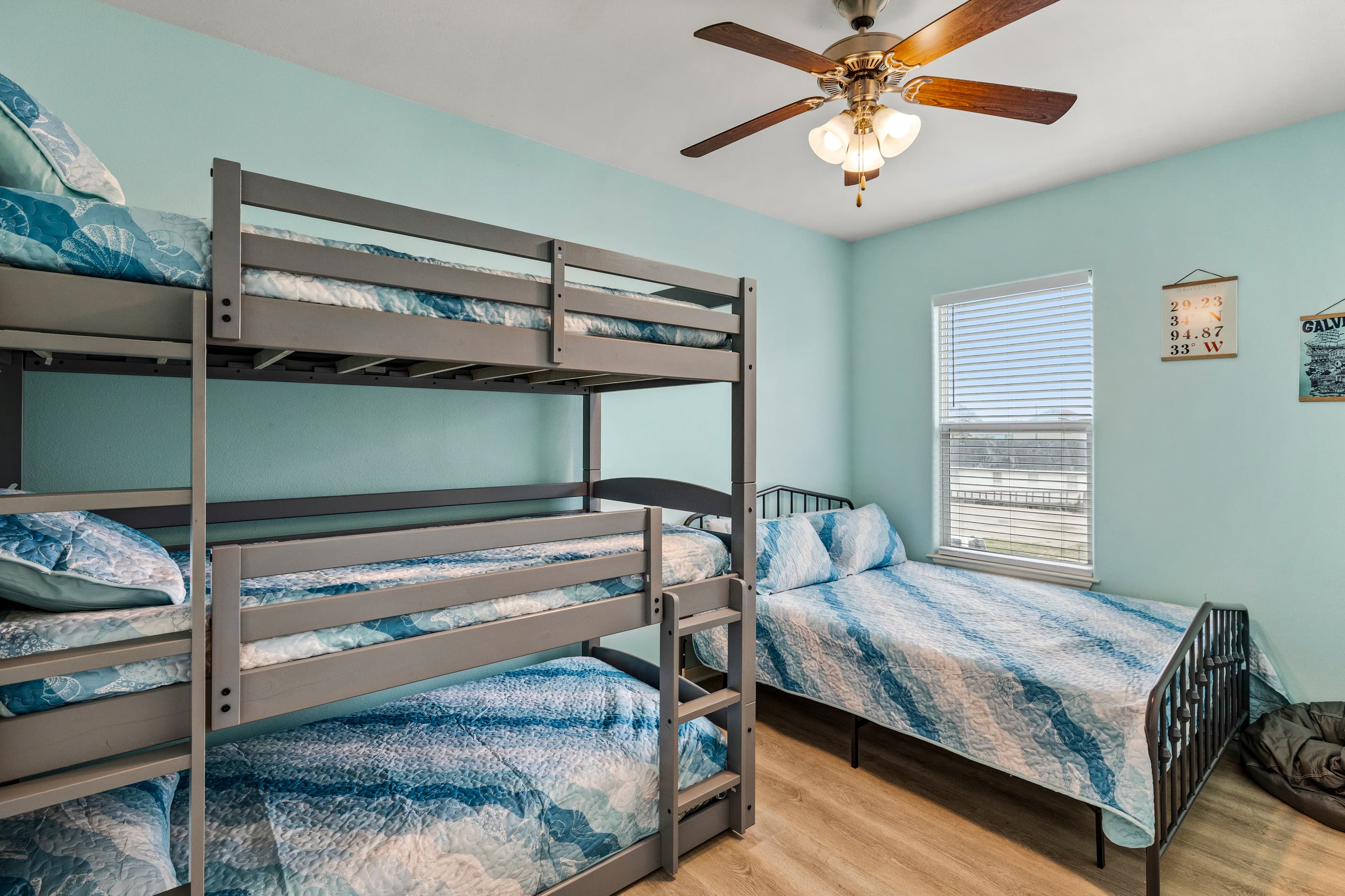 Bedroom 3 at Summer Bliss — bunk beds with ocean-themed bedding alongside a queen bed. Perfect for kids, teens, or groups who love the adventure of the top bunk.