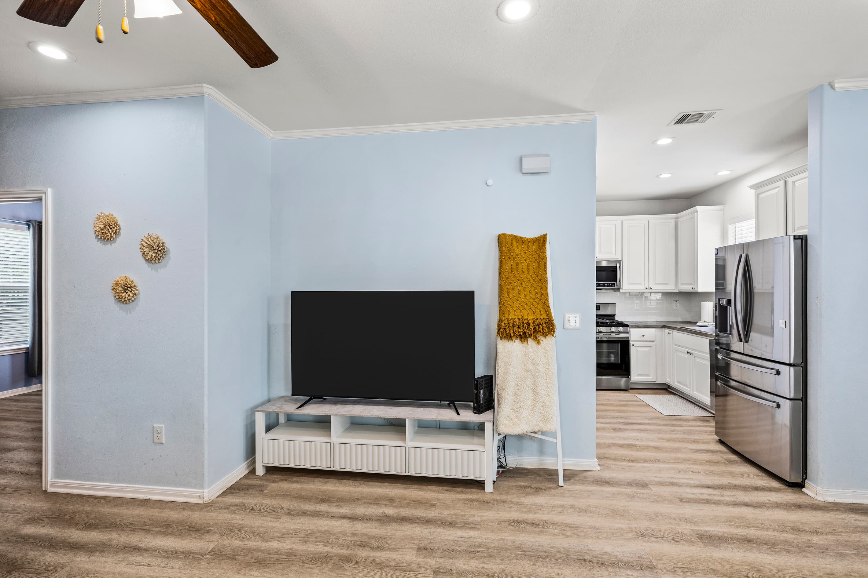 The open living area at Summer Bliss flows directly into the kitchen — smart TV, hardwood floors, and an easy layout for families and groups of up to 9.