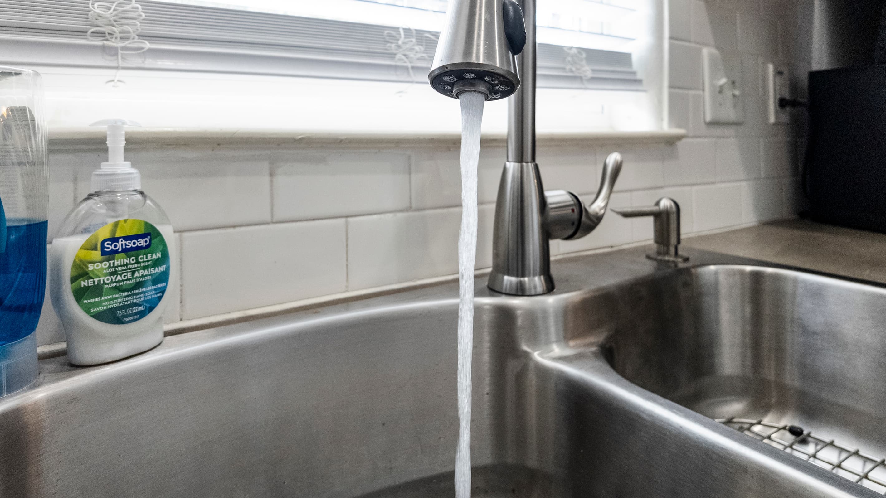 The kitchen sink at Summer Bliss — stainless steel, deep basin, and a front yard view. The small details that make a vacation rental feel like home.