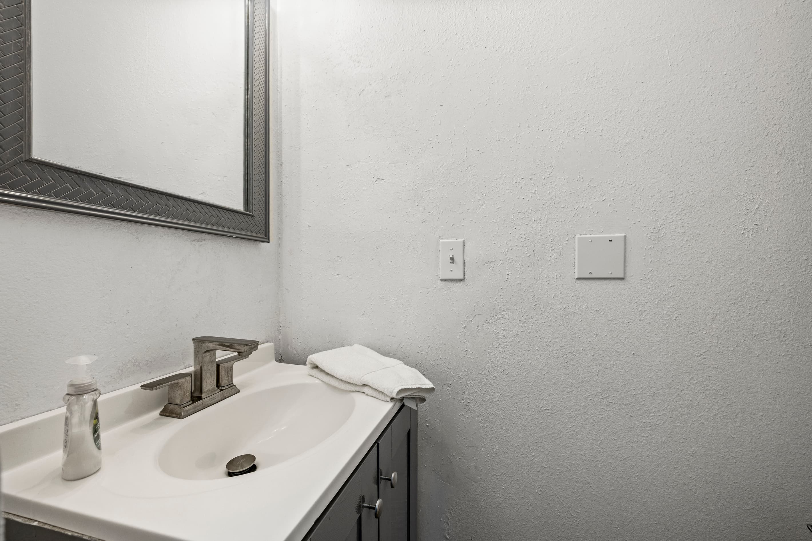 The half bath at Summer Bliss — a clean vanity on the main level, convenient for guests without needing to go upstairs.