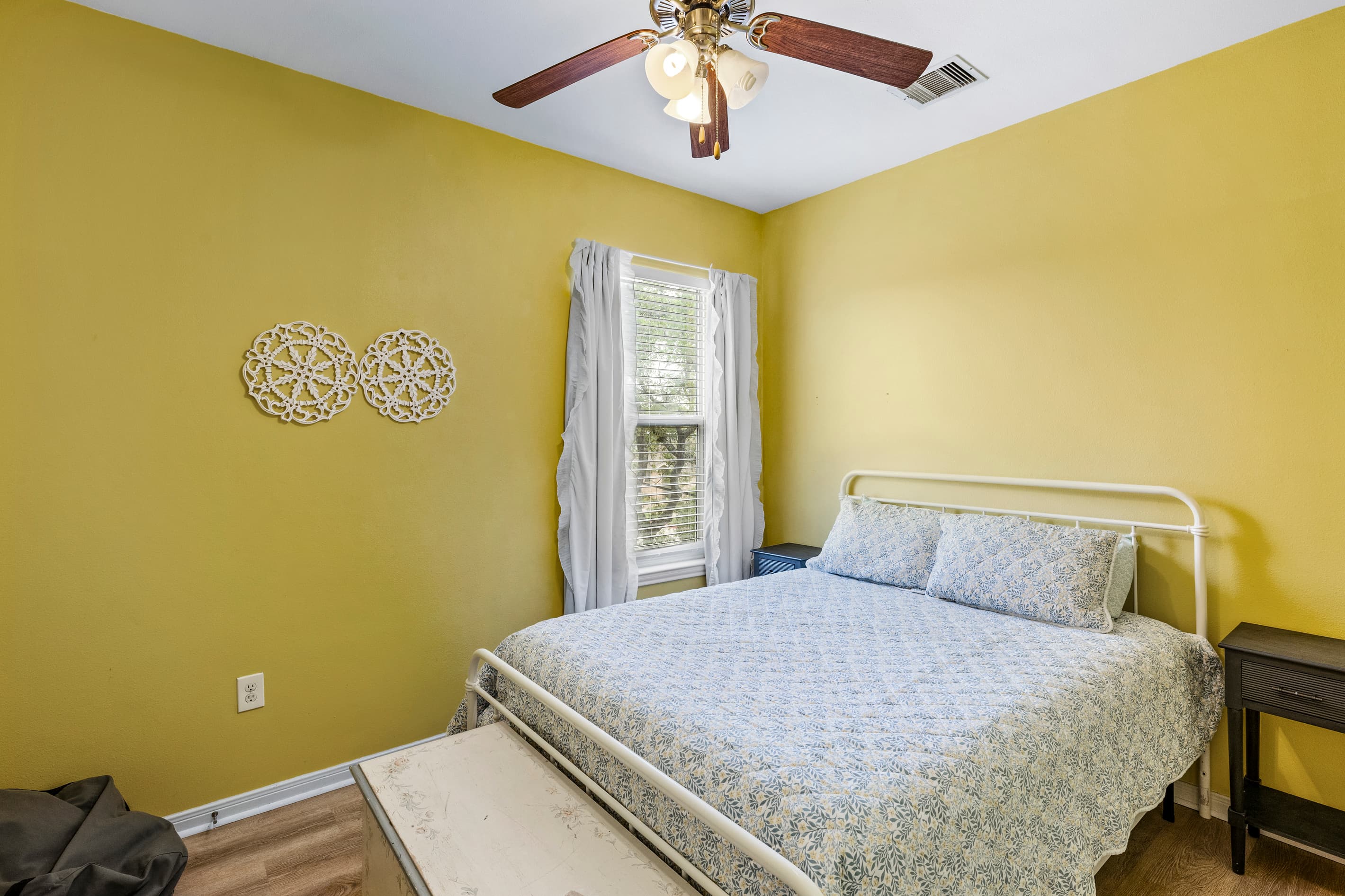 Bedroom 2 at Summer Bliss — a bright queen bedroom with a sunny yellow palette and cozy bedding. A cheerful retreat after a day on the Galveston beach.