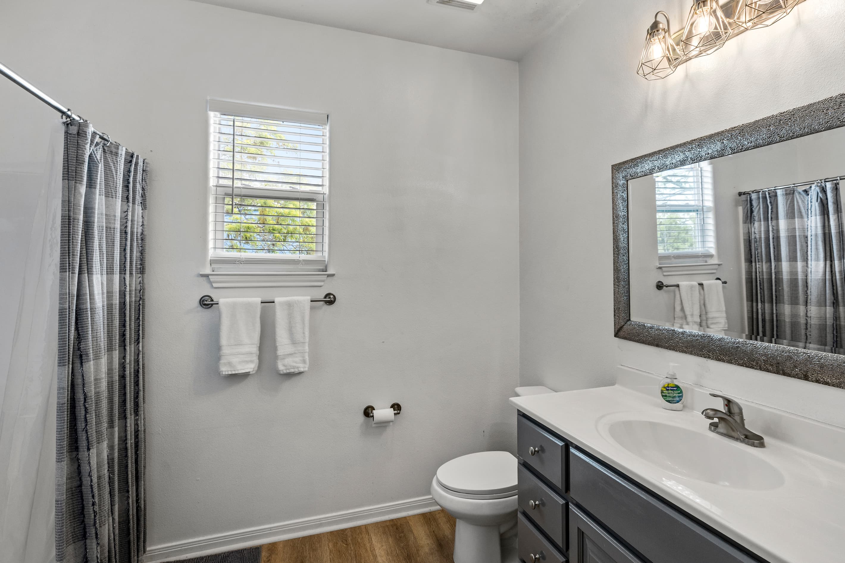 The upstairs guest bathroom at Summer Bliss — vanity sink, mirror, and fresh towels provided. Shared between Bedroom 2 and Bedroom 3.