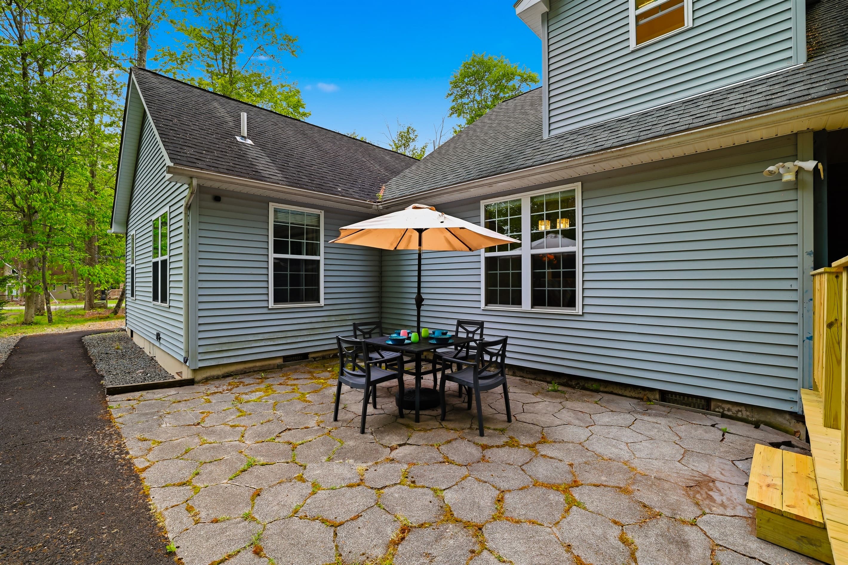 Small seating area in the back of the house. Table with umbrella and chairs.