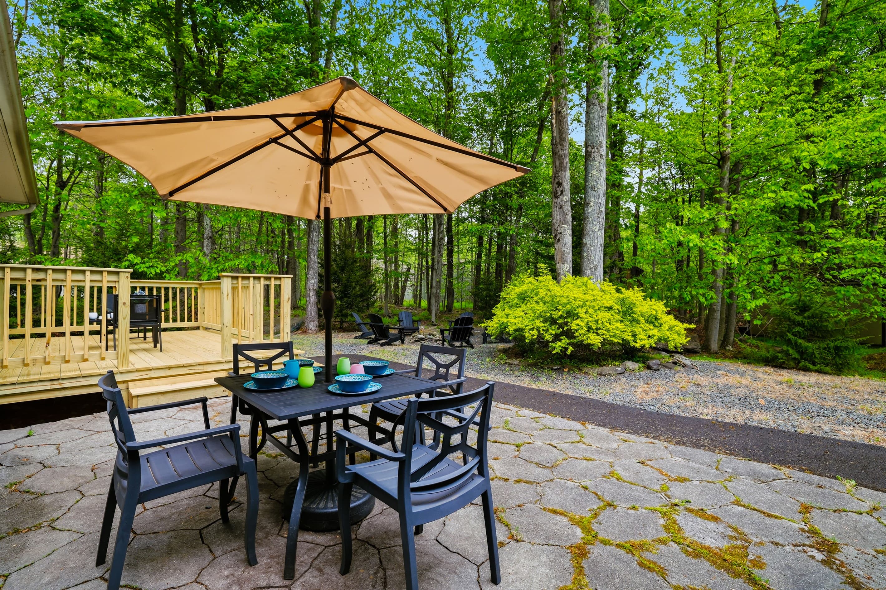 Small seating area in the back of the house. Table with umbrella and chairs.