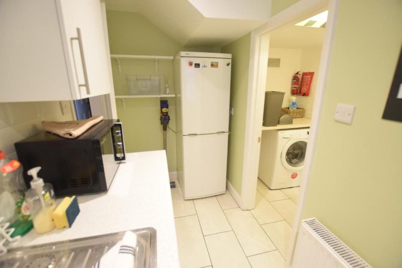 Utility room - fridge-freezer, washing machine, microwave, shelving (angle 1)