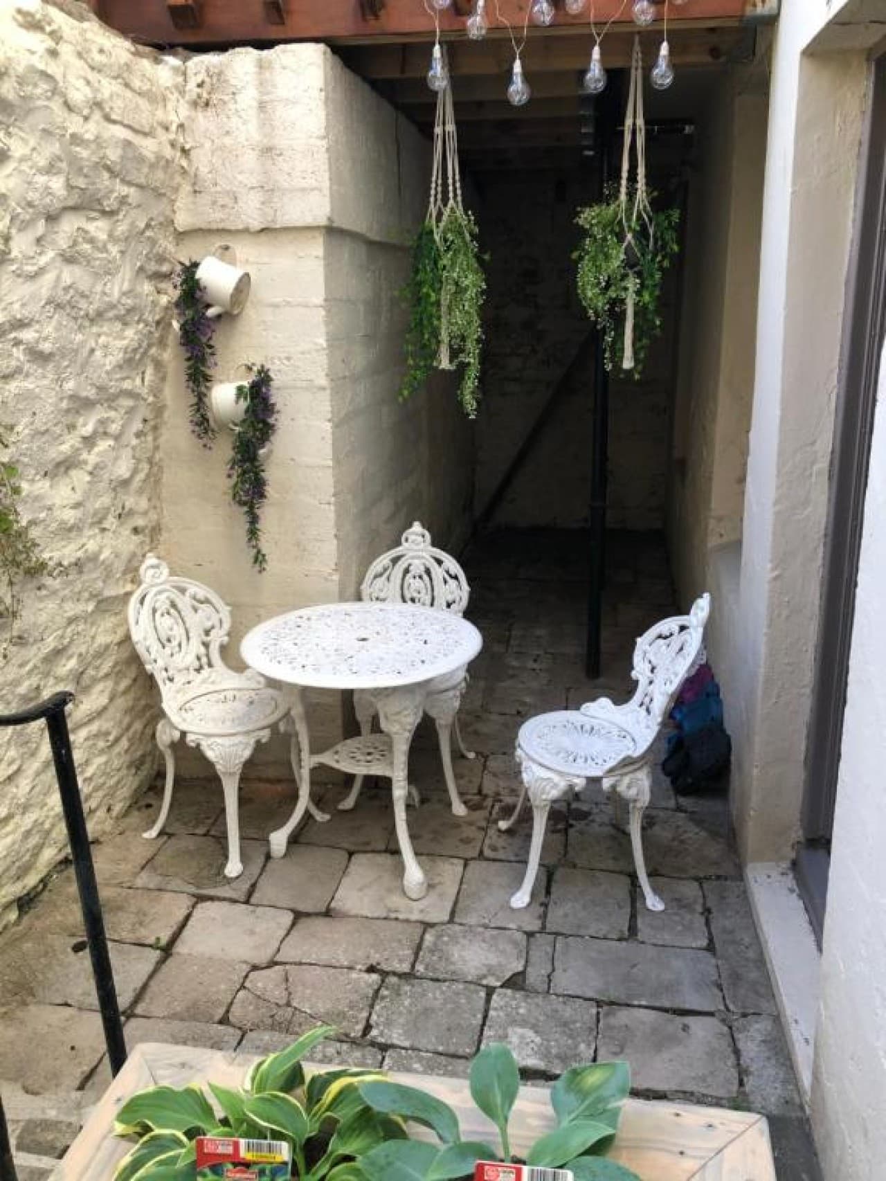 Courtyard terrace - bistro table and chairs, hanging lights, ivy, potted plants