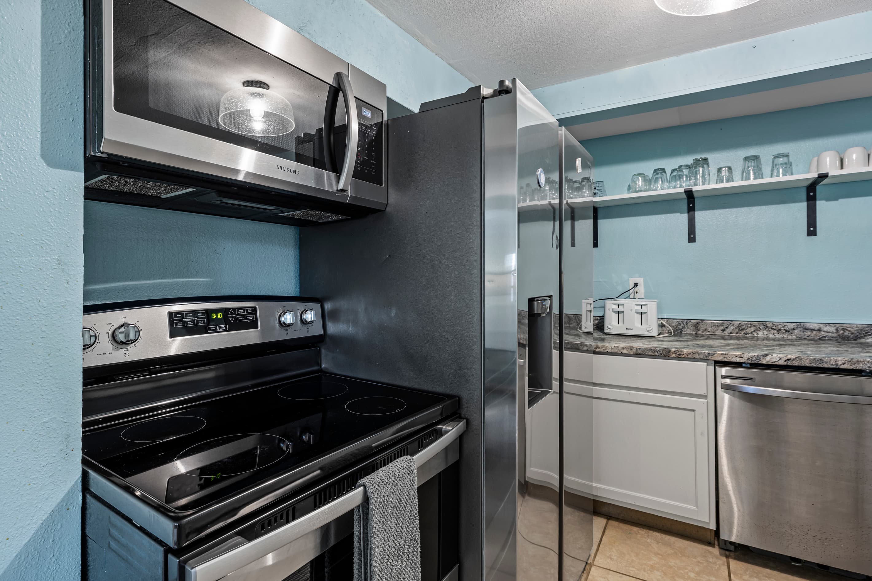 A fully equipped kitchen with granite countertops, open shelving, and all the tools you need — no need to eat out every night, though the Strand is just minutes away.