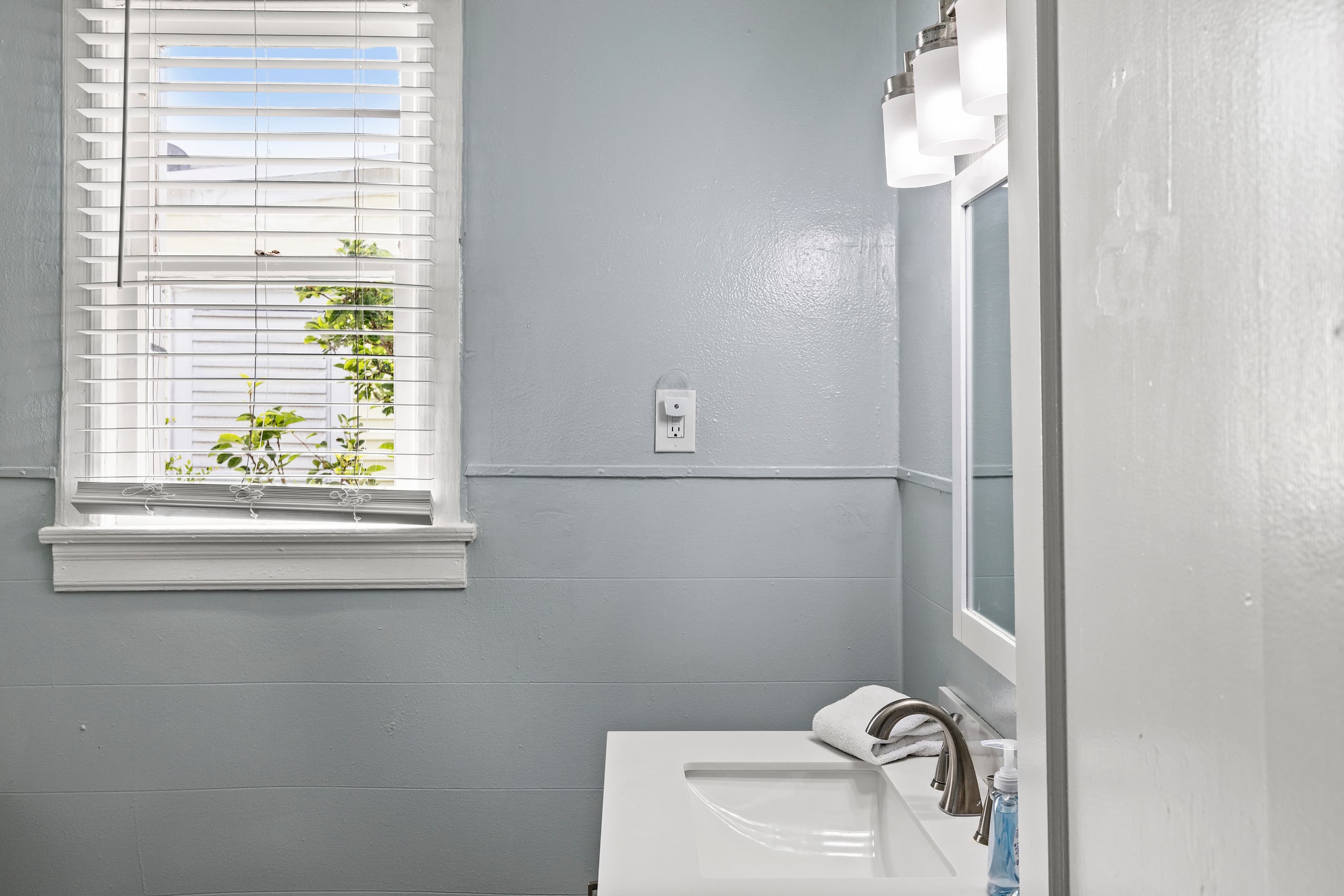A bright, clean vanity with ample mirror space keeps morning routines running smoothly — fresh towels and all essentials are provided for your stay.