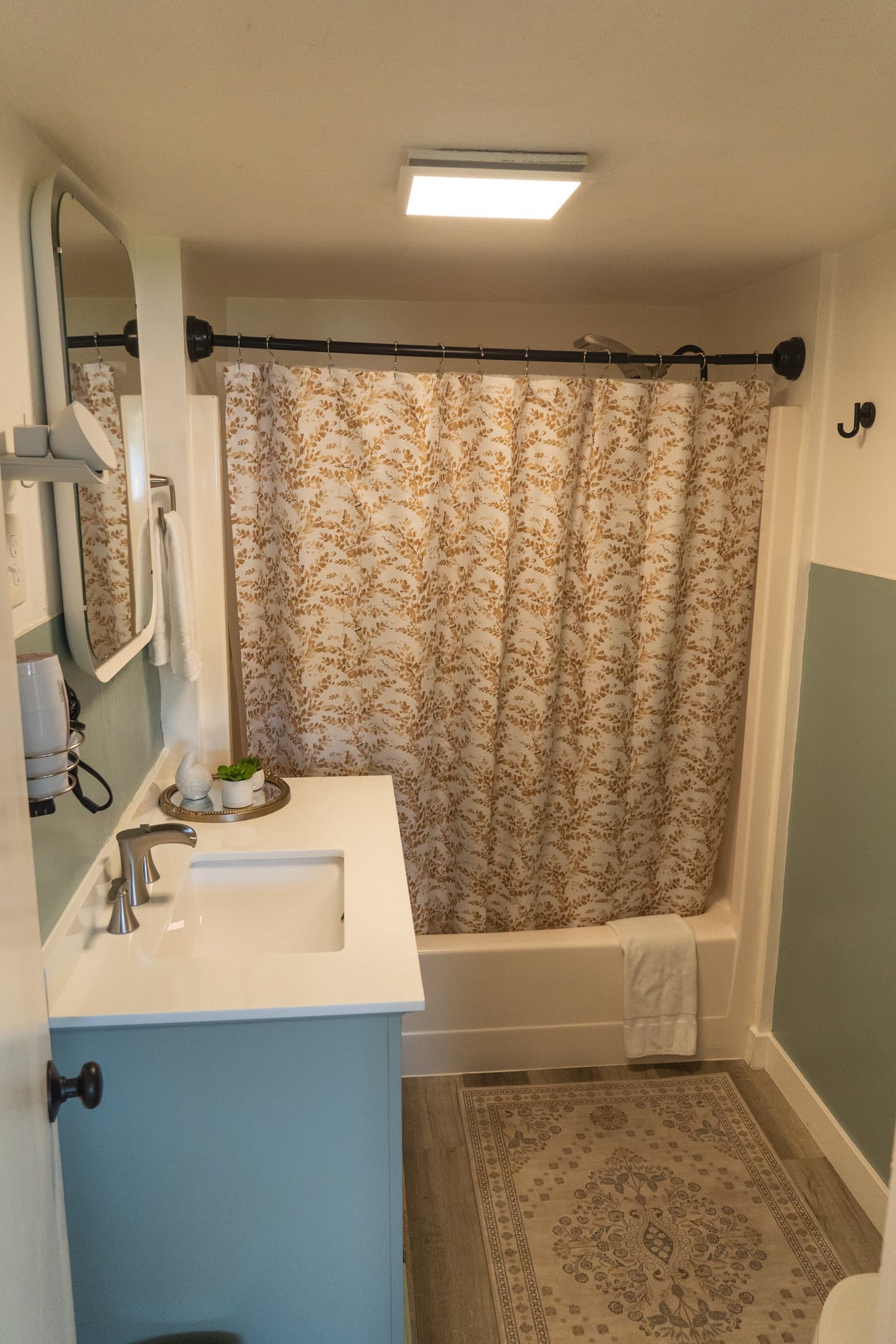 A bright bathroom with a full tub and shower combo, designed for comfort and everyday ease.