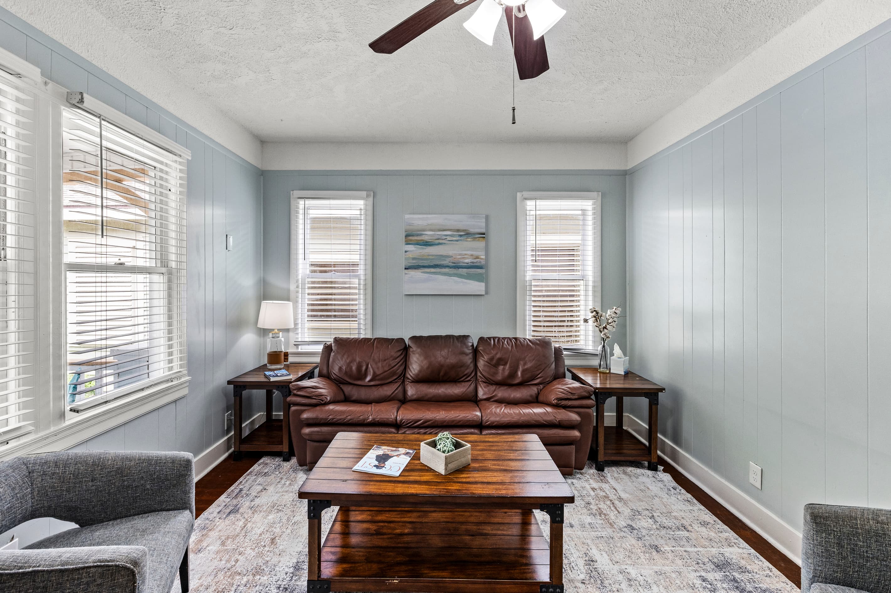 Sink into the leather sofa at Port Side at M — the living room is roomy, relaxed, and full of historic character in the heart of Lost Bayou.