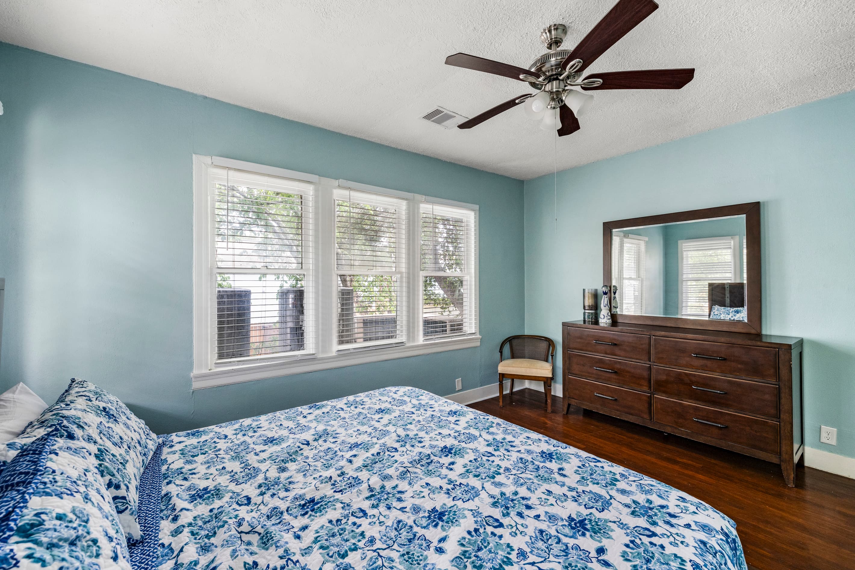 Wake up to natural light in the king primary suite — original hardwood floors and classic Galveston character throughout.