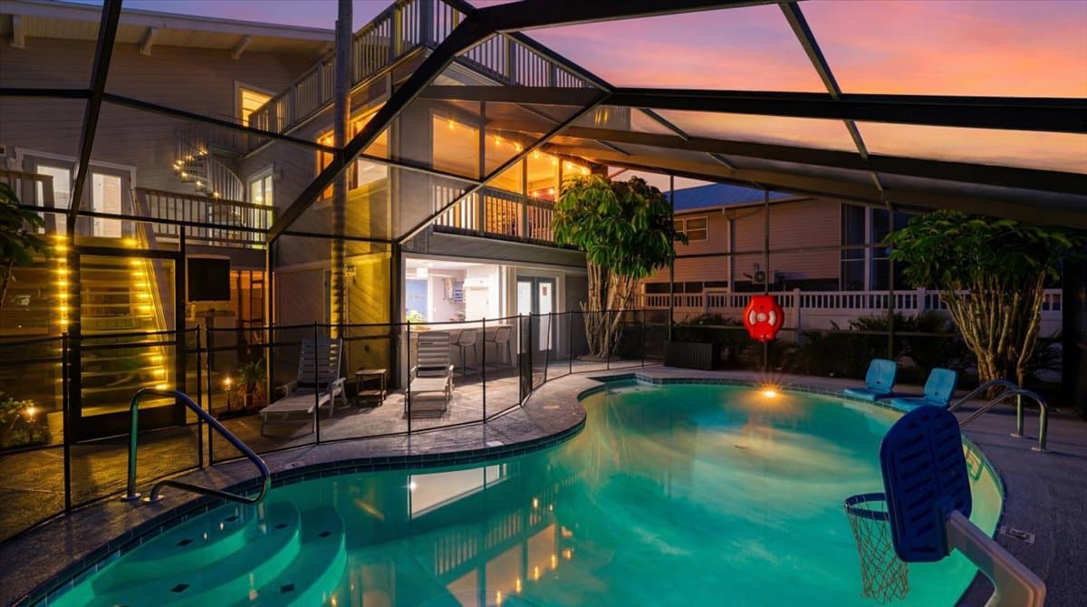 Heated saltwater pool with removable safety fence and screened enclosure.