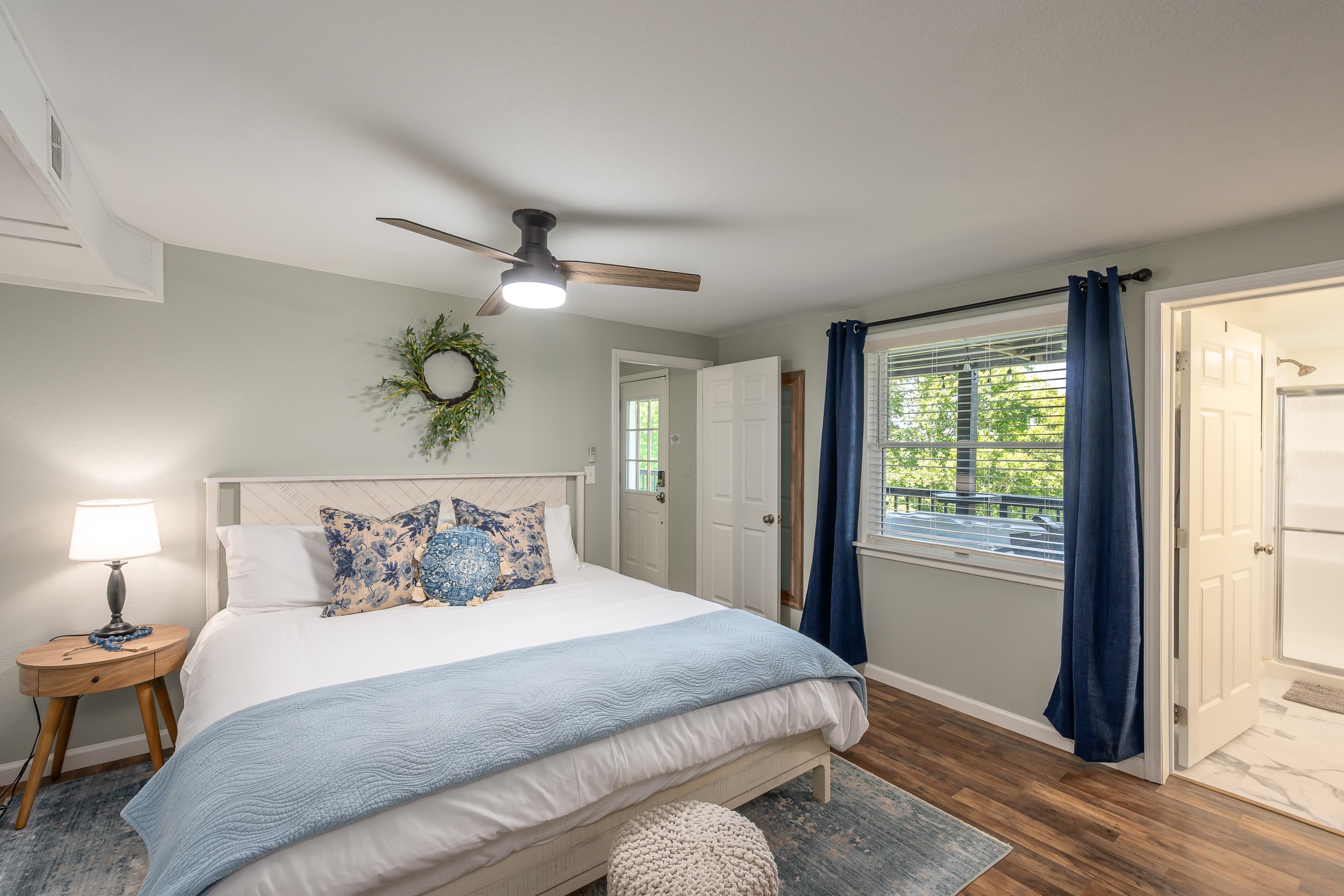 Lower level king bedroom with its own ensuite bathroom. View of hot tub and lake out the window. 