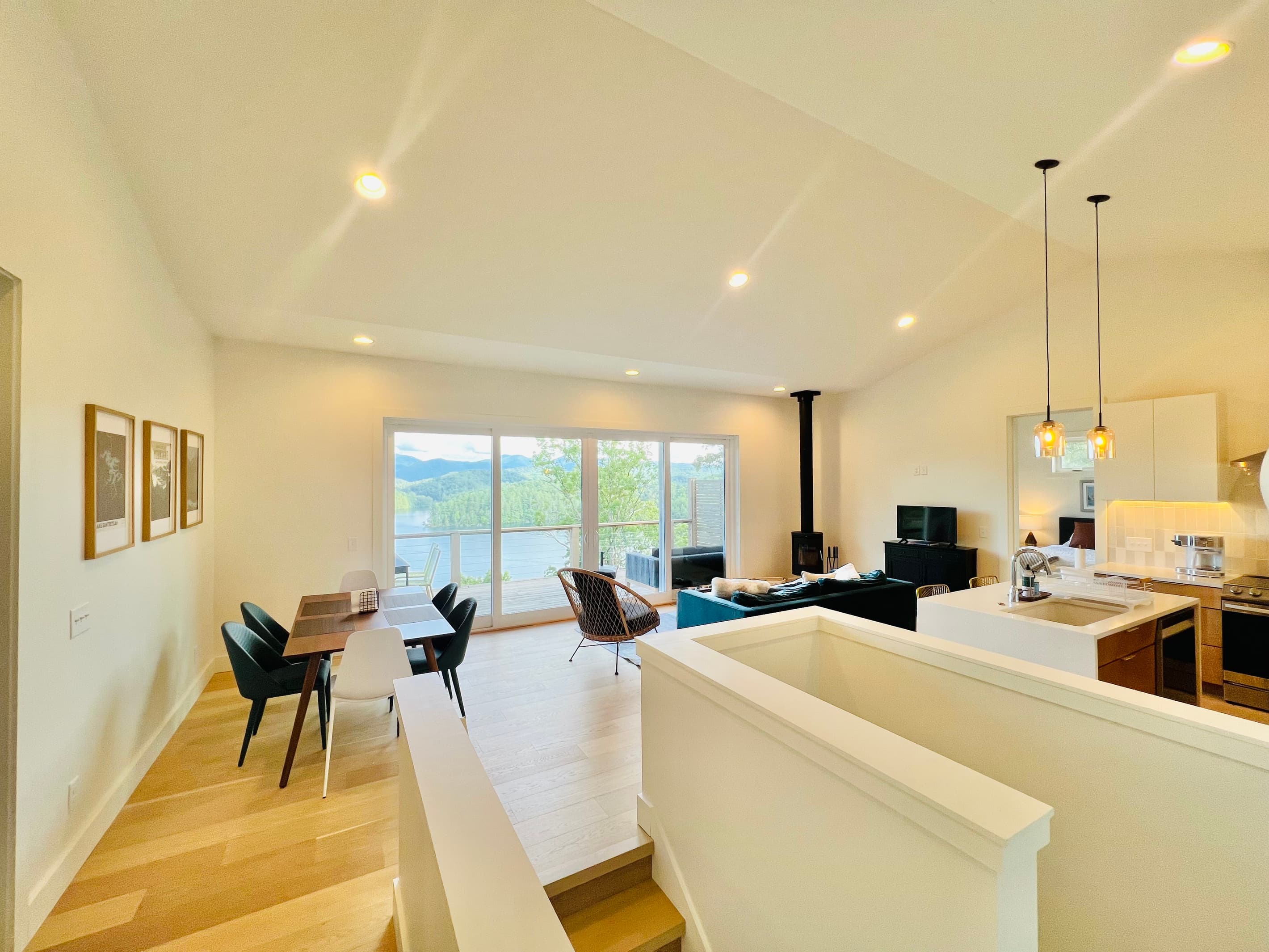 Gather with a view. The open-concept main level combines the kitchen, dining area, and living room into one inviting space. Large sliding glass doors open to the covered deck, where sweeping views of Lake Santeetlah and the mountains take center stage.
