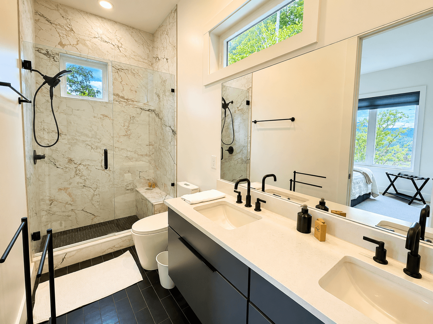 A spa-inspired retreat with a view.
The primary suite bathroom features a double vanity, oversized tiled shower, and thoughtful modern finishes designed for relaxation after a day on the lake.