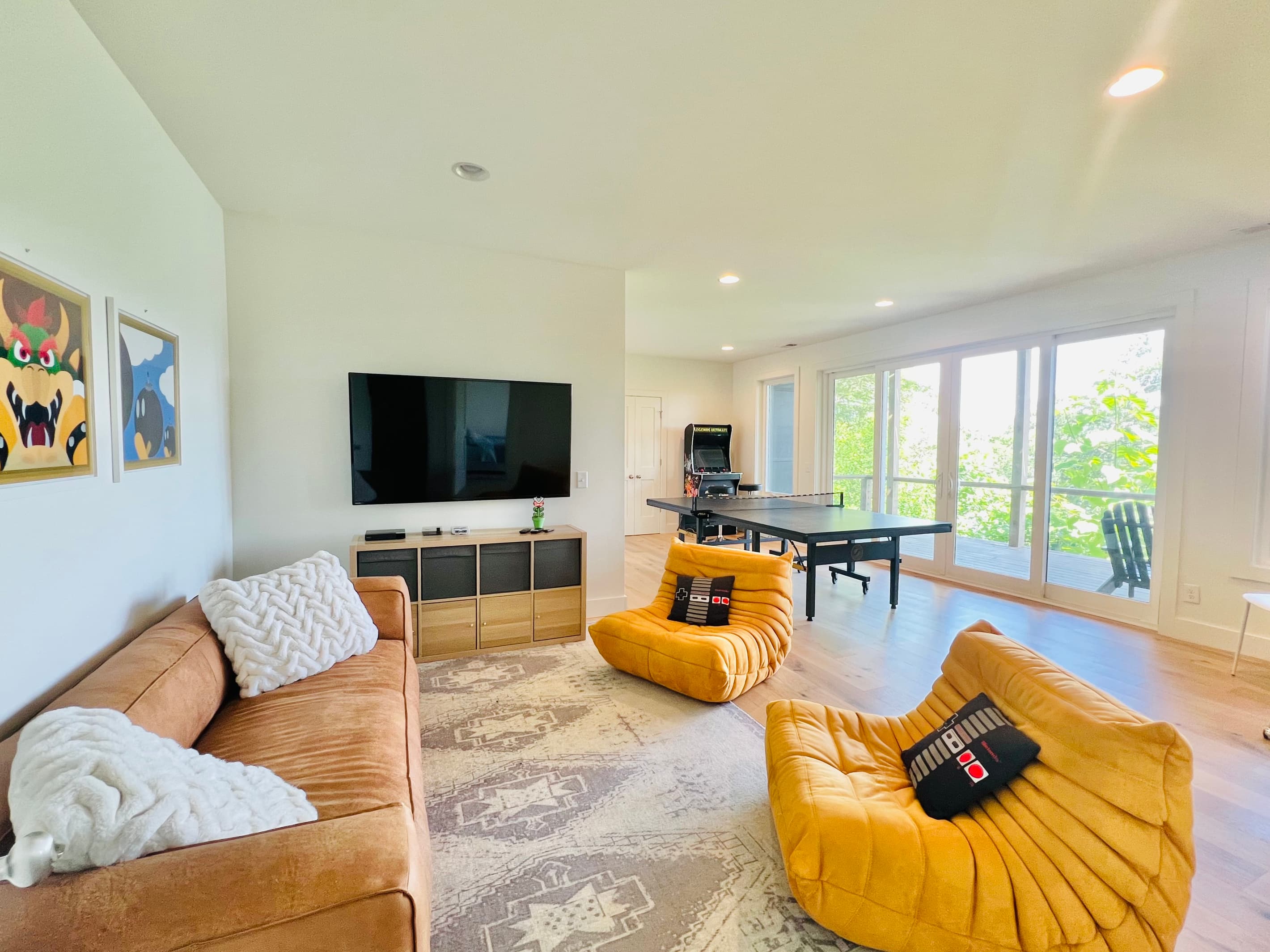 Game on.
The lower-level rec room is designed for fun, featuring a large Smart TV, arcade game console, ping pong table, comfortable seating, and direct access to a covered deck overlooking Lake Santeetlah.