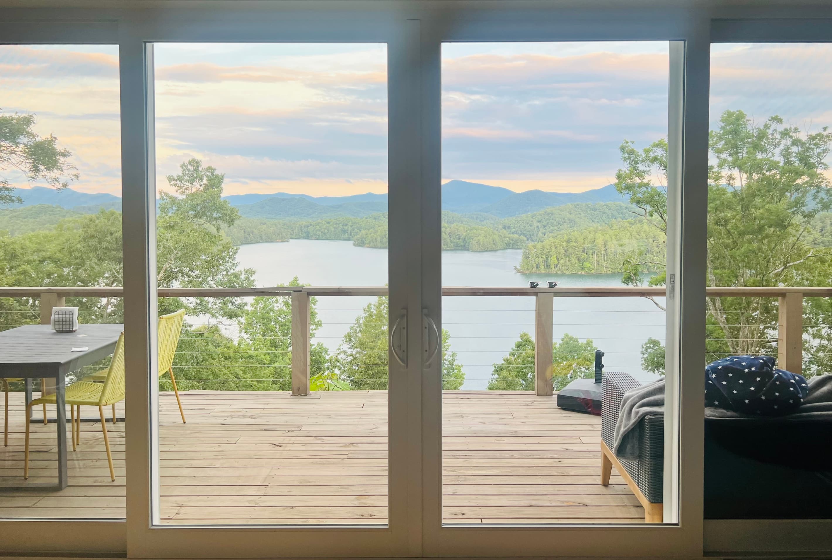 The best seat in the house. ☕🏔️ Wake up to sweeping views of Lake Santeetlah and the Smoky Mountains from the comfort of Hidden Point House.