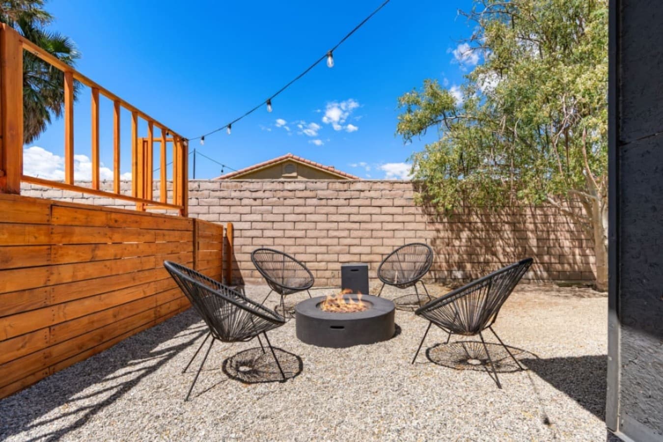 Cozy outdoor seating area tucked beside wood fencing, perfect for morning coffee or evening chats.