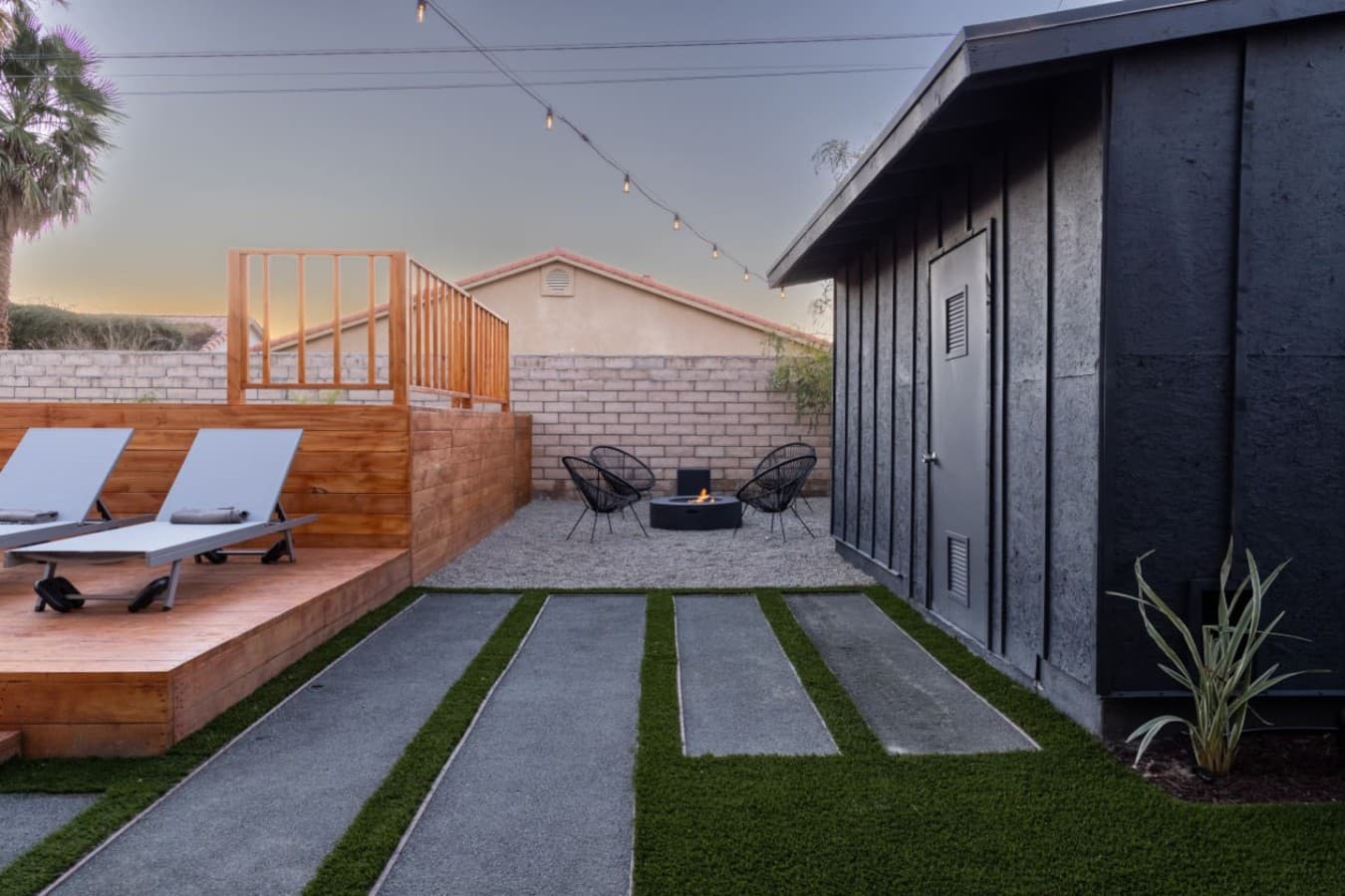 Quiet corner patio w/ loungers & chairs, offering a relaxed spot to unwind outdoors.